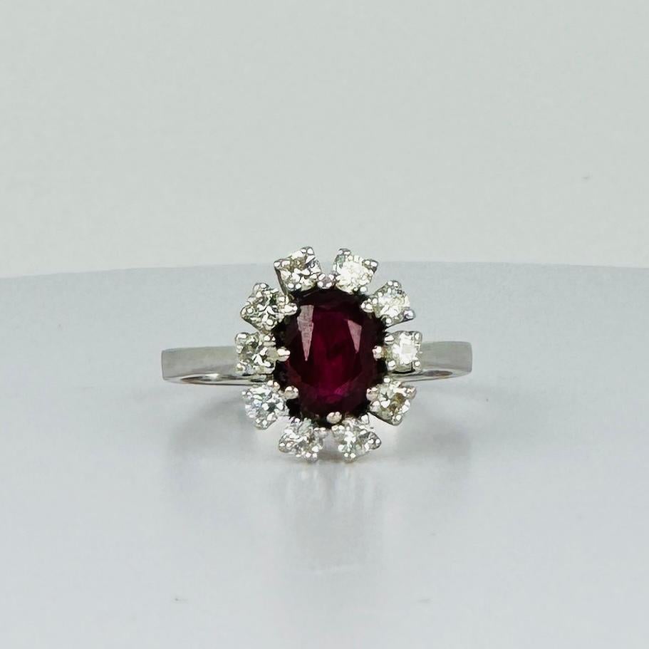 Experience the timeless elegance of this  14-carat entourage white gold ring, designed to captivate with its stunning interplay of diamonds and a radiant ruby centerpiece. This exquisite entourage ring features a 14k white gold band adorned with 10