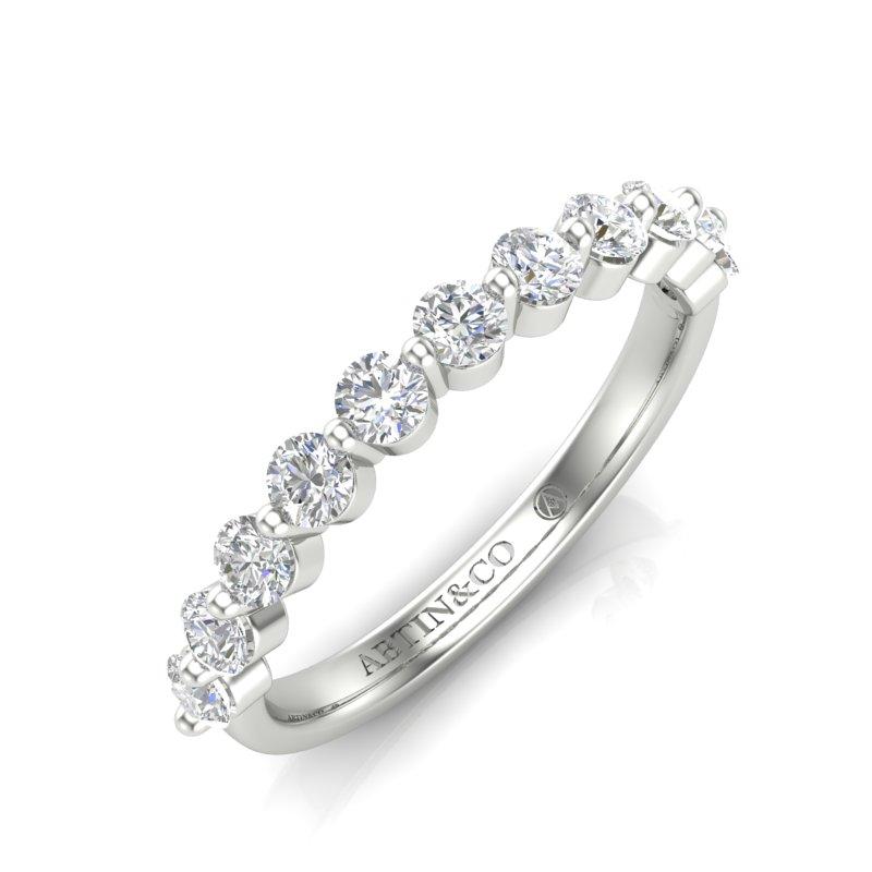 Crafted in 14K gold, this sparkling wedding ring expresses timeless simplicity with elegant style as 0.71 ct of floating diamonds along the band catches the light for a brilliant effect. This ring is stunning when worn alone or stacked with other