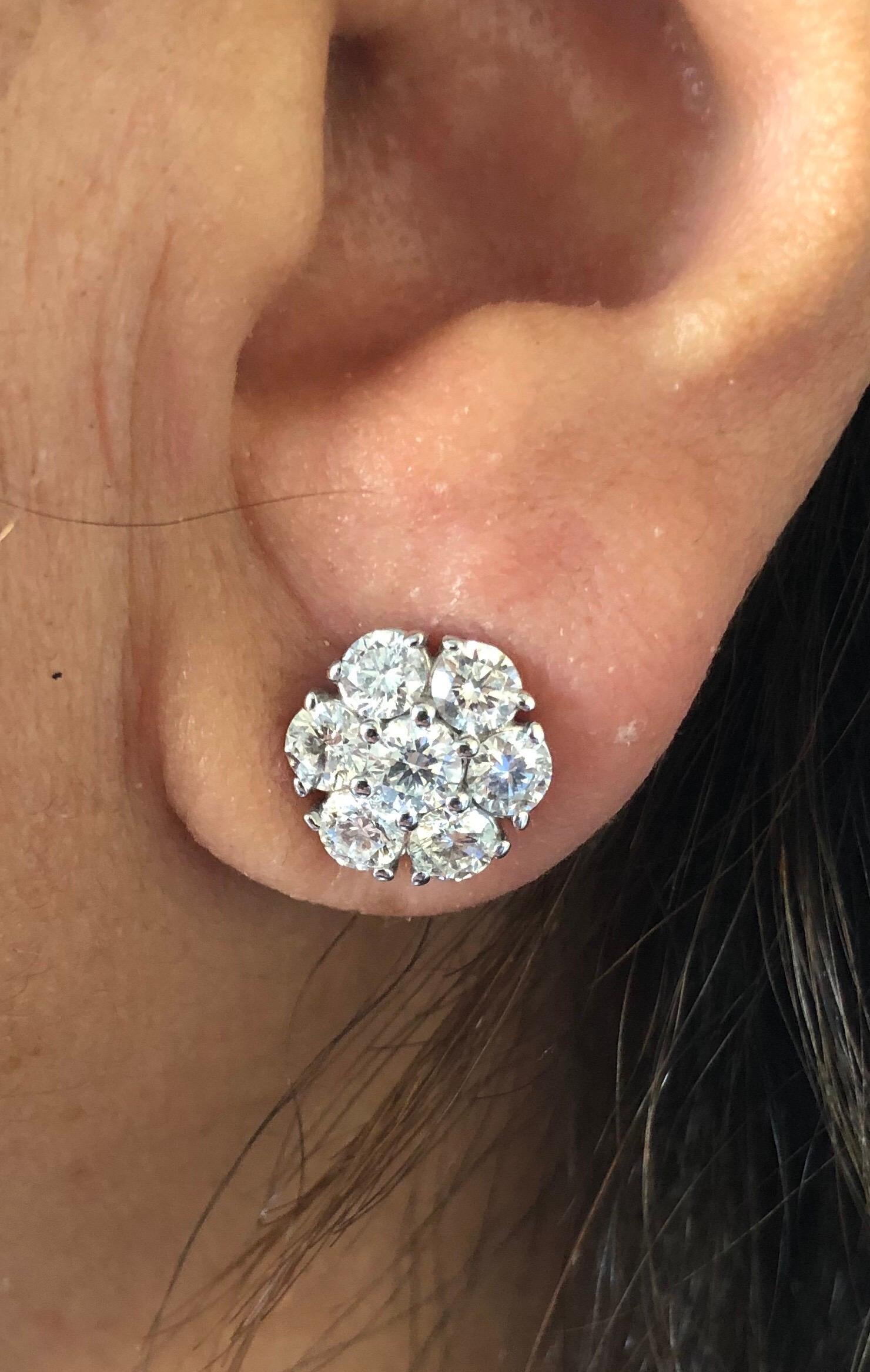 Flower cluster diamond earrings set in 14K white gold. The earrings are set with 14 diamonds each weighing 0.25 carats. The total weight of the earrings is 3.50 carats. The color of the stones are G-H, the clarity is SI. The earrings are available