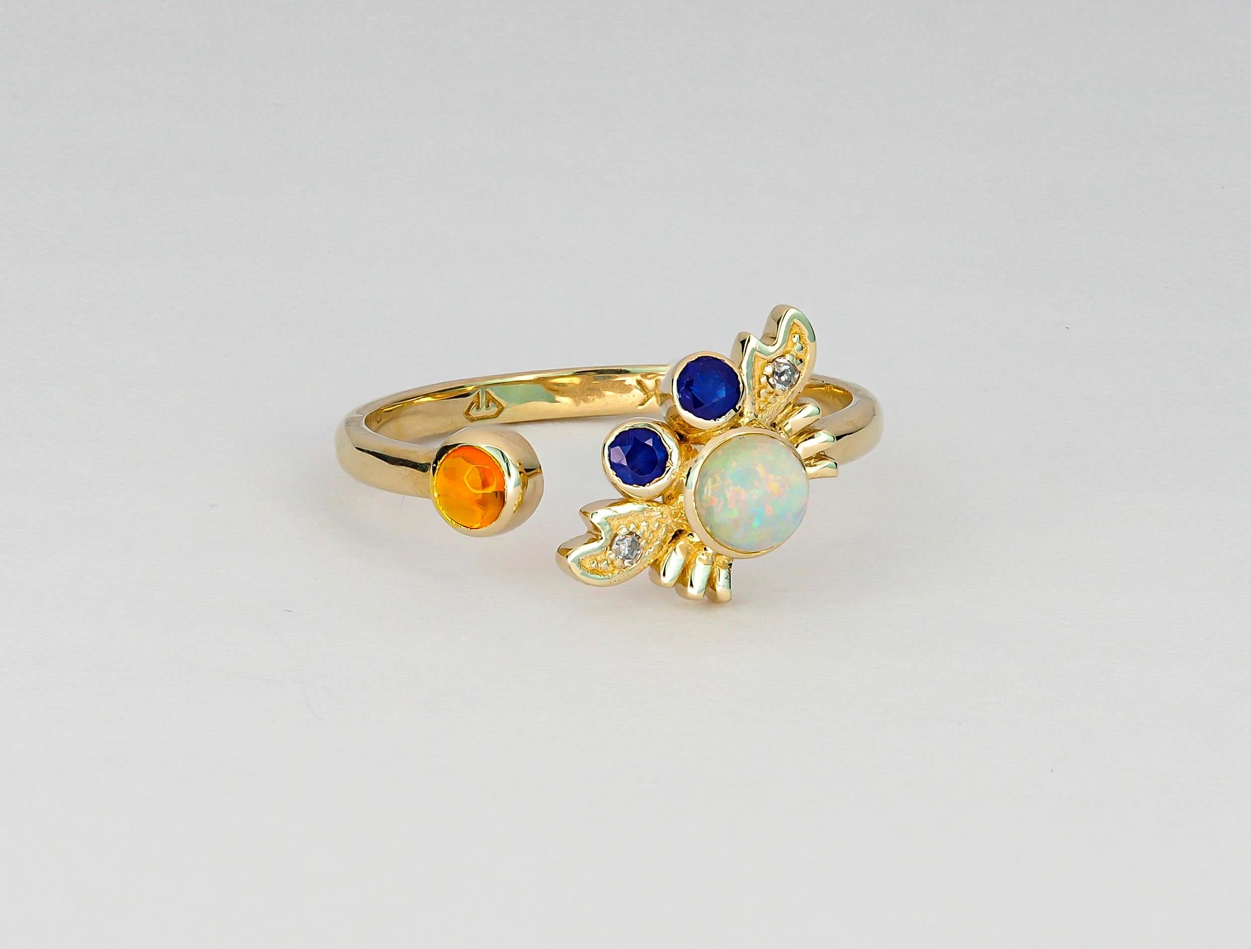 14 kt solid gold Funny crab ring with natural opal, sapphires and diamonds. 
Weight: 1.95 g. 

Gemstones:
1. Natural opal: weight - 0.45 ct in total, color - multi colors, cabochon cut, 4.3 mm.
Clarity: Translucent  
2. Natural sapphire: weight -