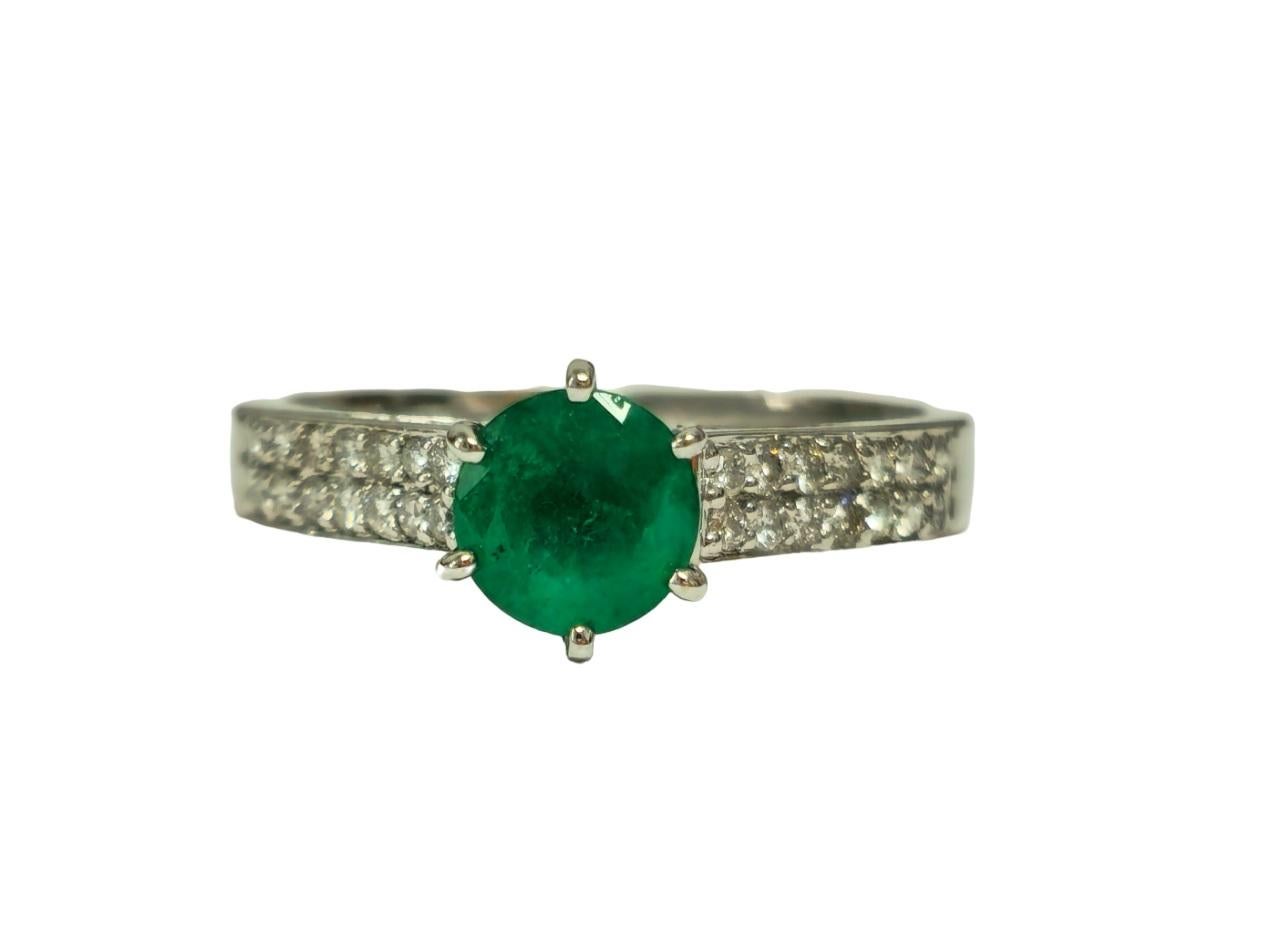 Rayonnez d'élégance avec notre bague en or blanc 14 carats, ornée d'une éblouissante émeraude colombienne de 0,50 CT de taille ronde. Soulignée par des diamants ronds de taille brillant de pureté VS-SI et de couleur G, cette bague respire la