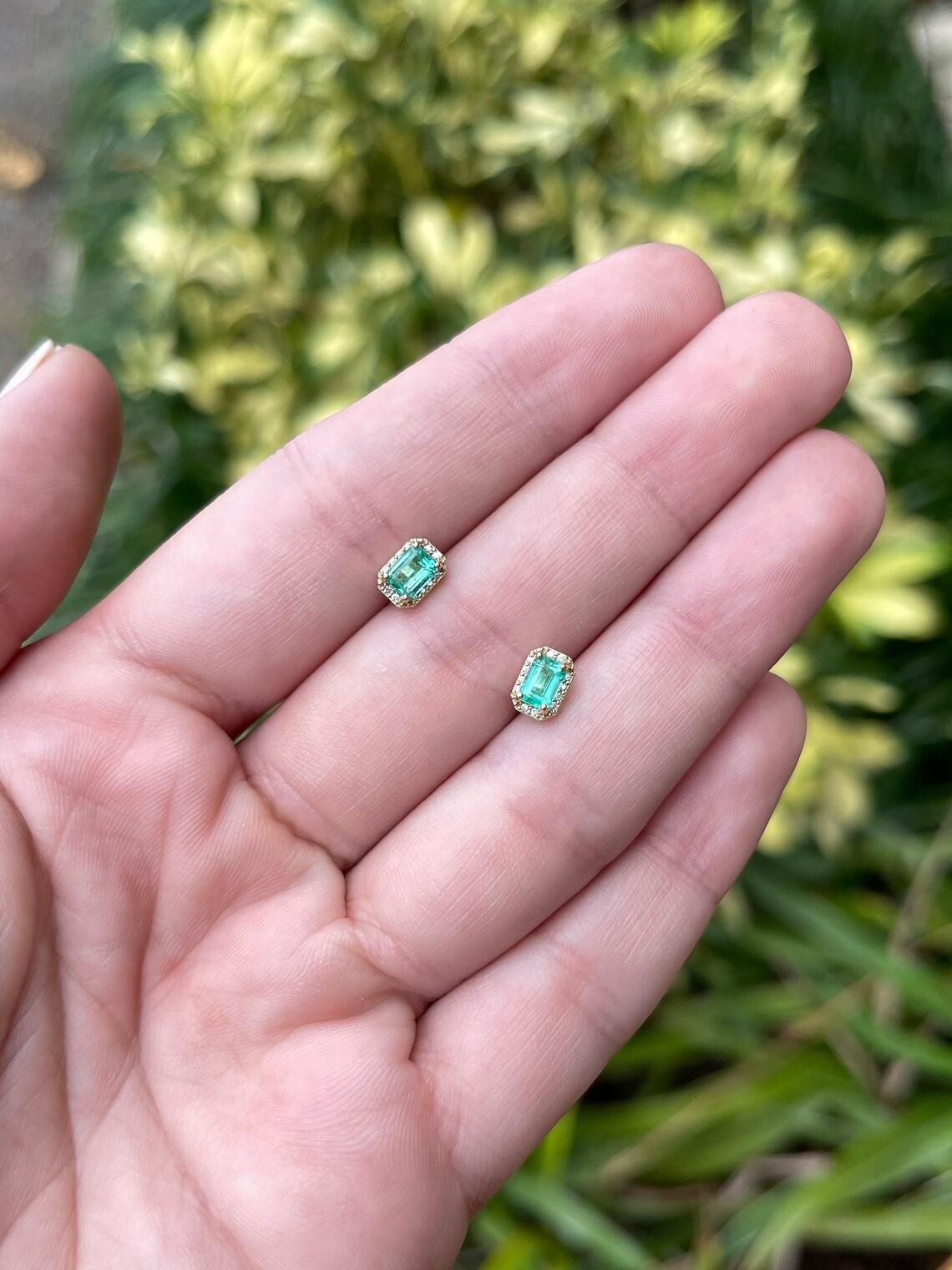 In questo caso si tratta di un orecchino con smeraldo taglio petite e diamante in oro giallo 14K. Gli smeraldi sono di un verde vibrante e di una trasparenza incredibile, accentuati da una semplice montatura in oro a quattro punte. Gli smeraldi