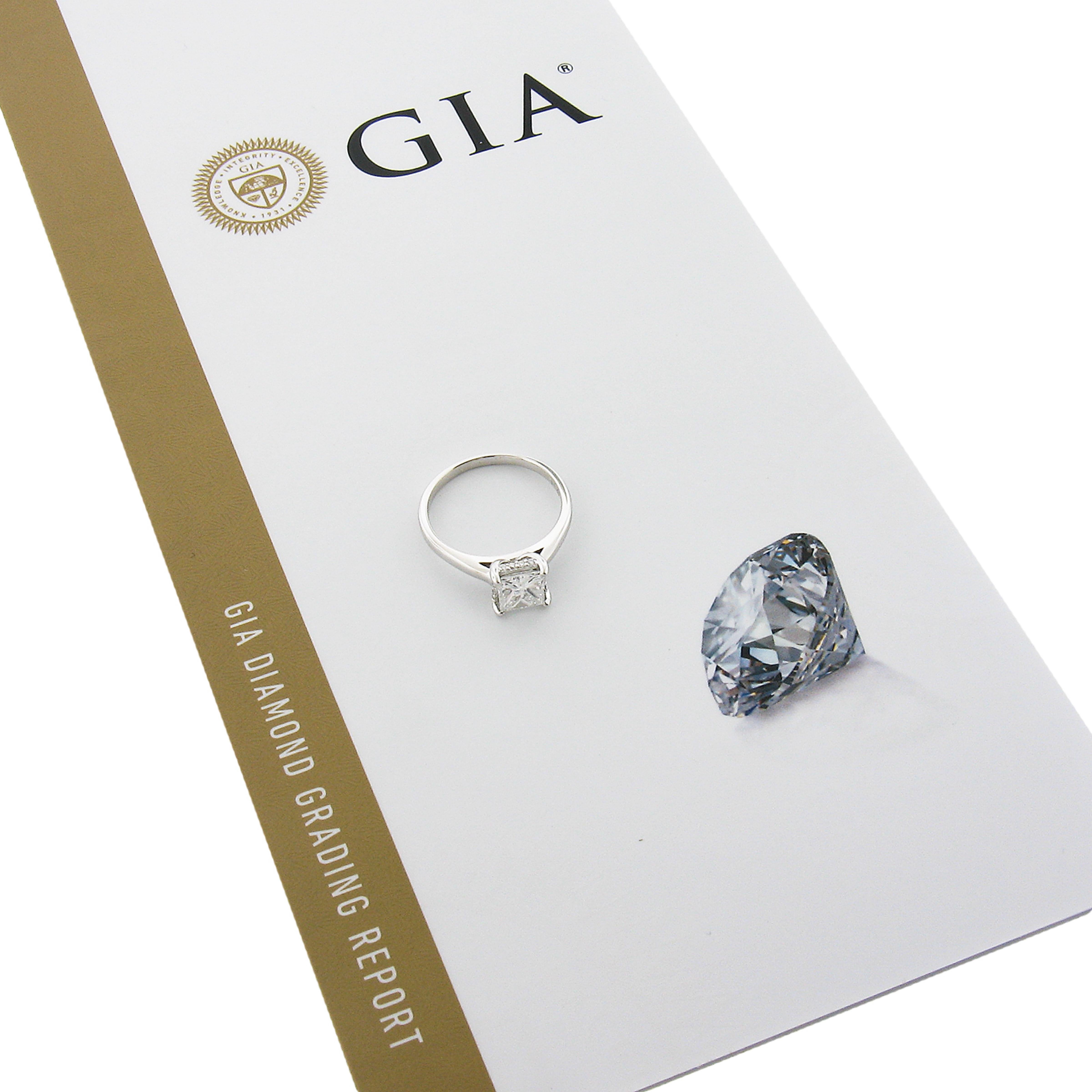 This super elegant diamond solitaire engagement ring is newly crafted in solid 14k white gold. It features a fine quality, GIA certified, princess cut diamond that weighs 1.02 carat with colorless (E color) and super clean (VS2 clarity). There is a