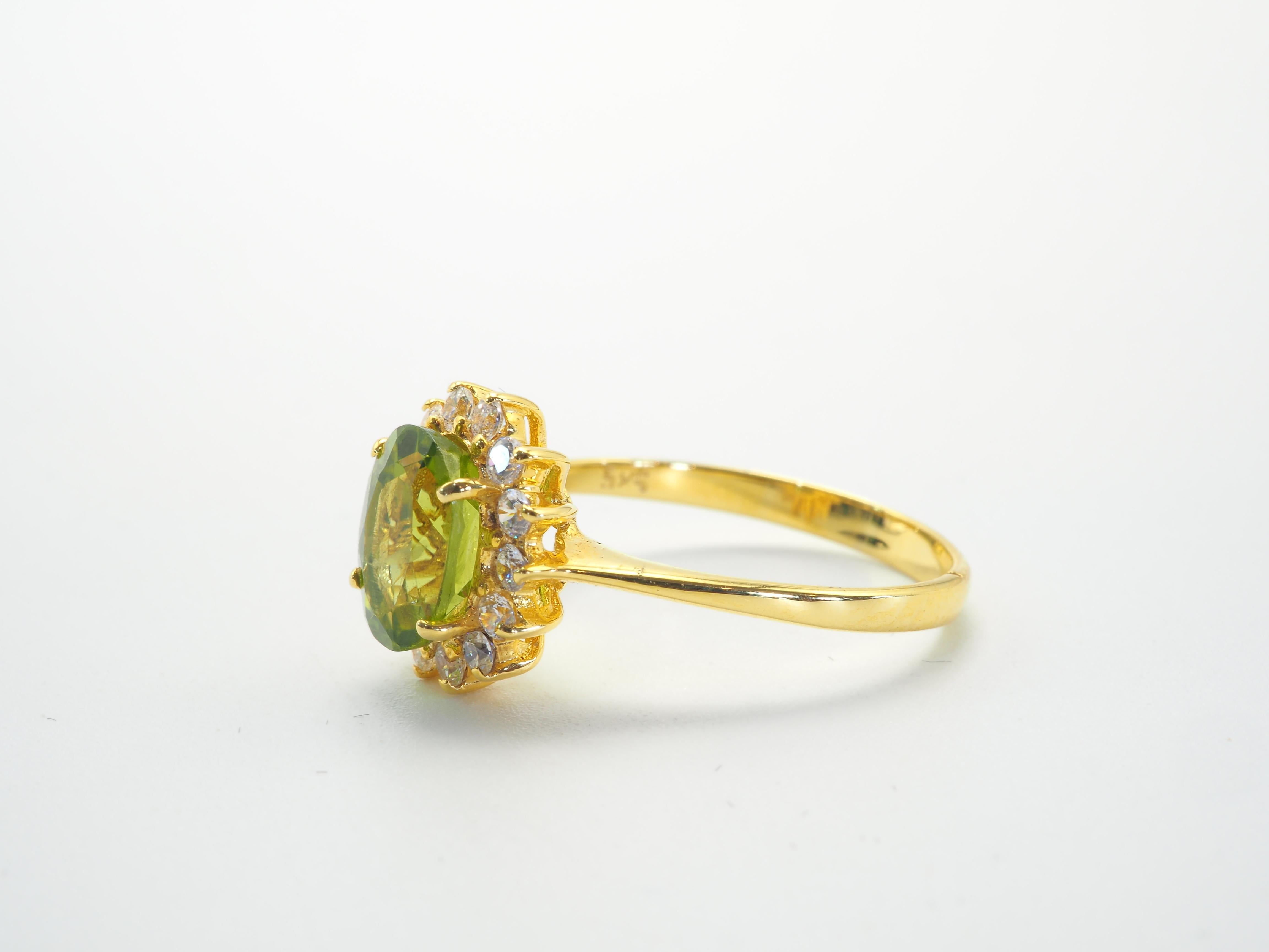 Timeless popular style ring equipped with the increasingly popular peridot gemstone- the August birthstone, and surrounded by many wonderful, brilliant cut cubic zirconia. It is a worn ring with some scratches and loss notable on the shank-