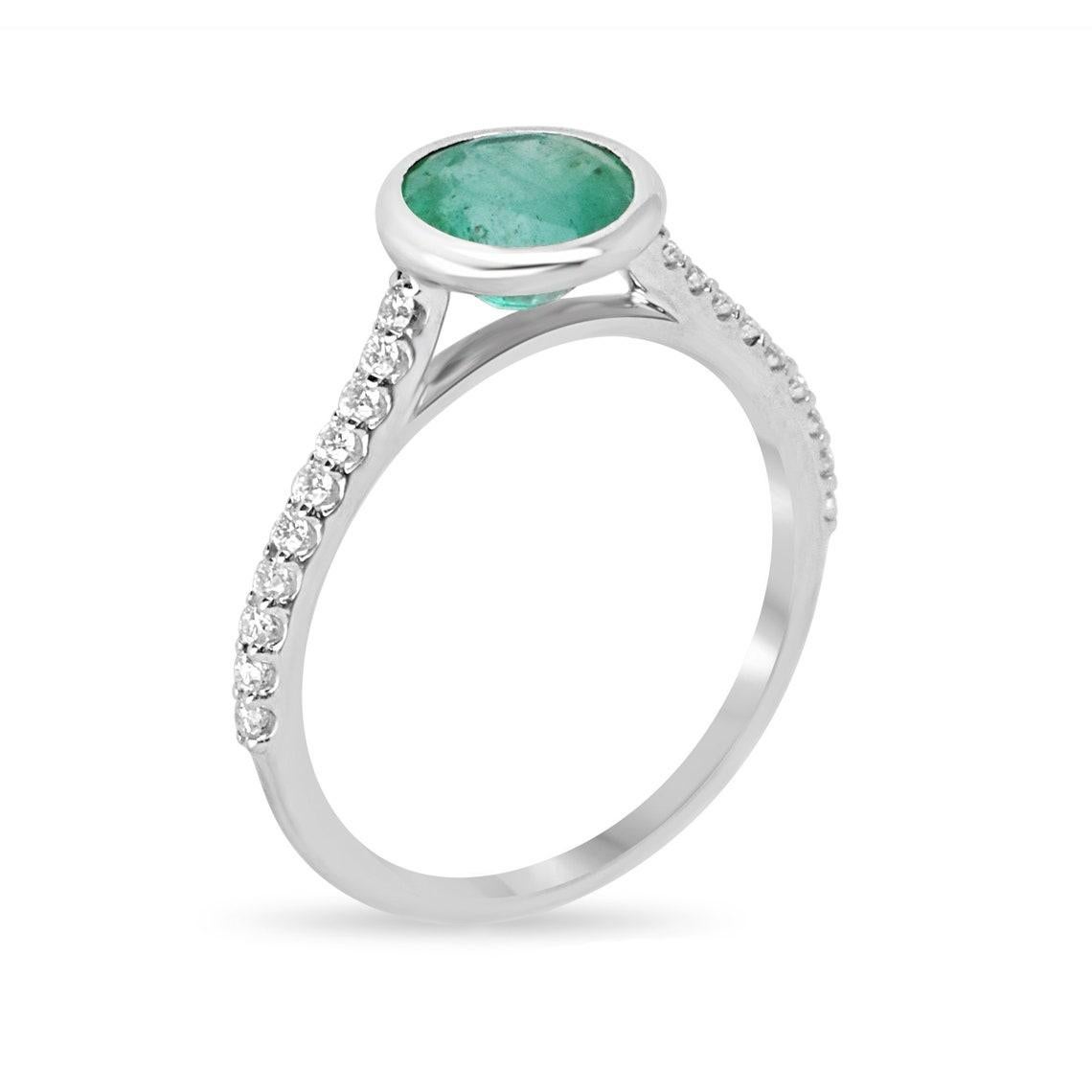 Rehaussez votre style avec notre bague émeraude et diamant, qui met en vedette une fascinante émeraude de taille ronde, d'une teinte vert foncé moyen et d'une clarté semi-transparente. Elle est habilement sertie en chaton pour mettre en valeur sa