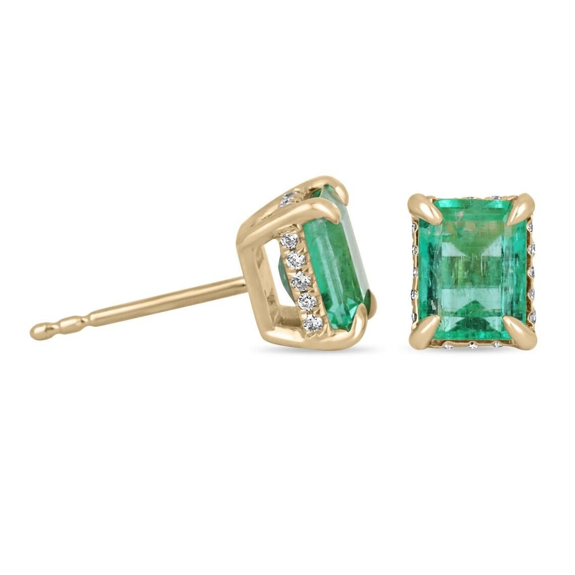 Se muestra un elegante par de pendientes con halo de esmeralda y diamantes VS ocultos de magnífica calidad. Las hermosas gemas de esmeralda del centro se extraen de la tierra, se engarzan hábilmente y se colocan en un engarce seguro de oro amarillo