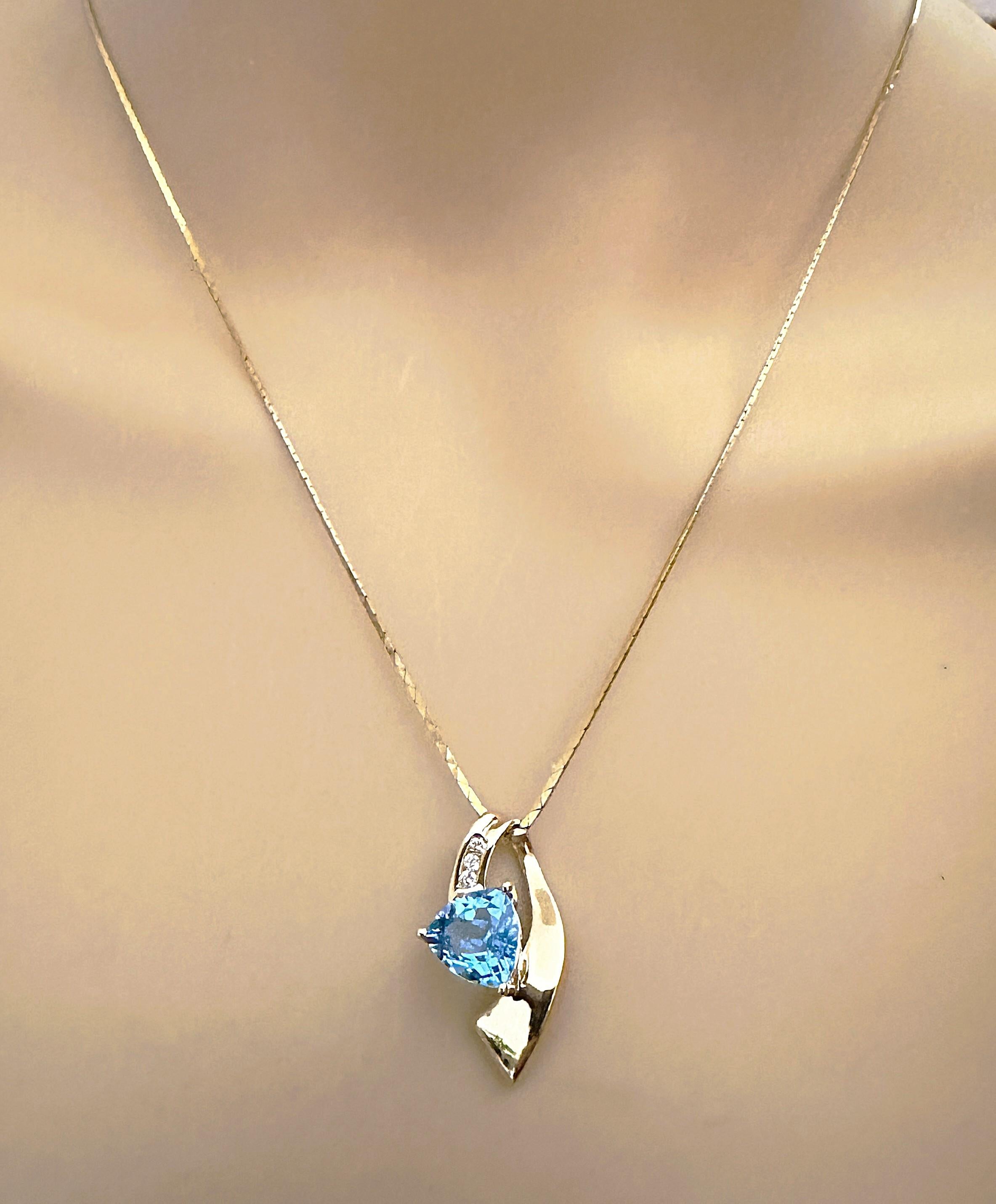 I love the design of this necklace.  It is made of 14k Yellow Gold and has a trillion cut blue topaz centerstone which measures 8.5 x 8.5 mm and is 2.25 cts.  It has three 2 mm brilliant cut diamonds on the pendant above the center stone.  The
