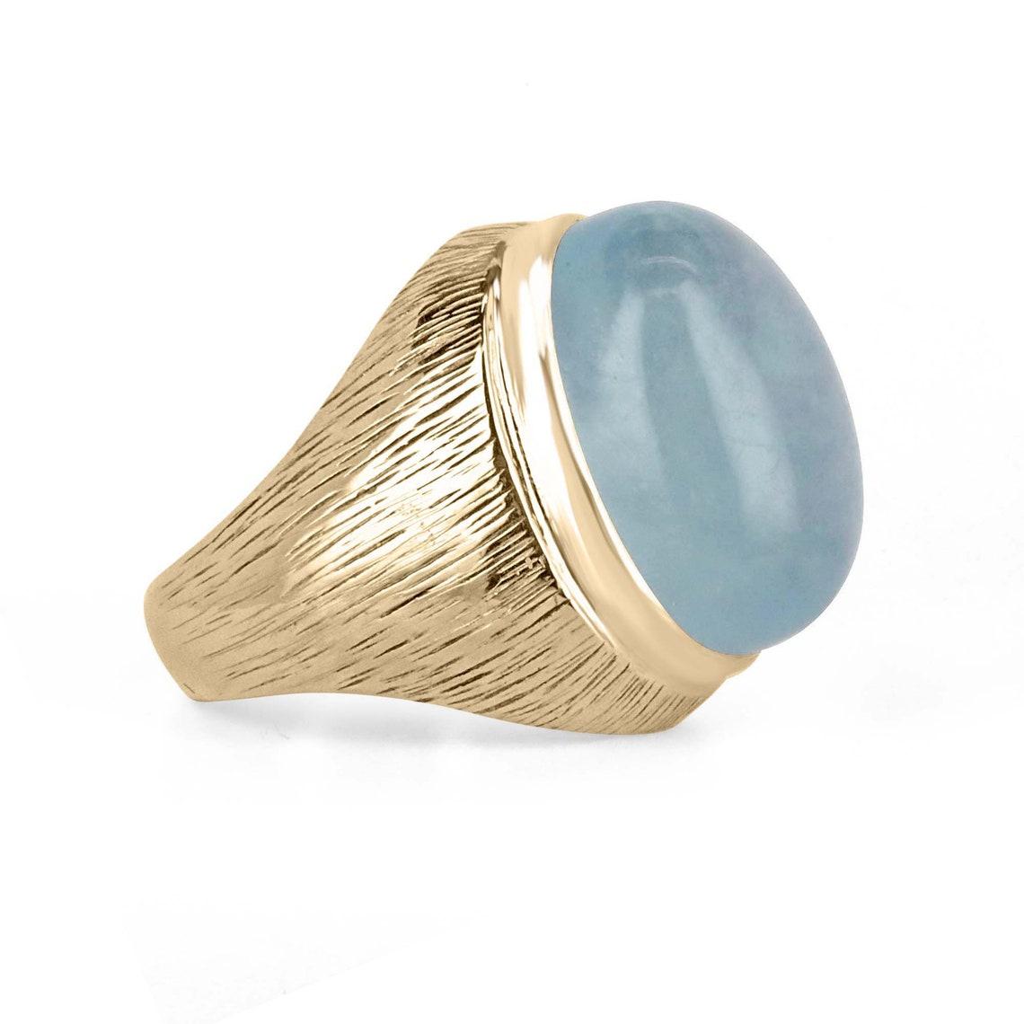 Dieser Solitärring verfügt über ein absolut atemberaubendes Herzstück in Form eines riesigen ovalen Aquamarins im Cabochon-Schliff von 26,97 Karat, der in einer massiven Solitärfassung aus 14 Karat Gelbgold gefasst ist. Der Aquamarin hat eine