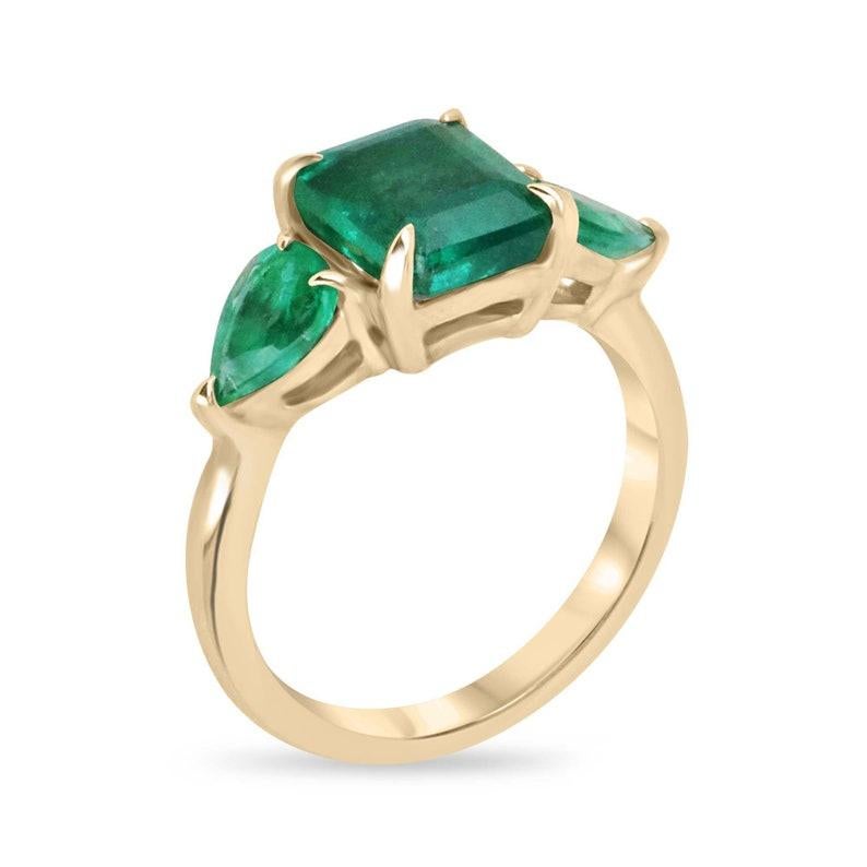 Introducing our stunning Emerald Trilogy Three Stone Ring, where the heart of Zambia graces the center with a luscious asscher-cut emerald, showcasing a captivating dark green hue and semi-transparent clarity, cradled in a secure four-claw prong