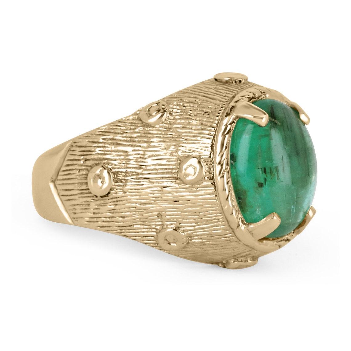 La bague présentée est un solitaire en or jaune 14 carats, taillé en cabochon, de forme ovale et massive, en forme d'émeraude. Cette magnifique bague solitaire porte une émeraude de 3,13 carats dans une monture unique à quatre griffes. L'émeraude