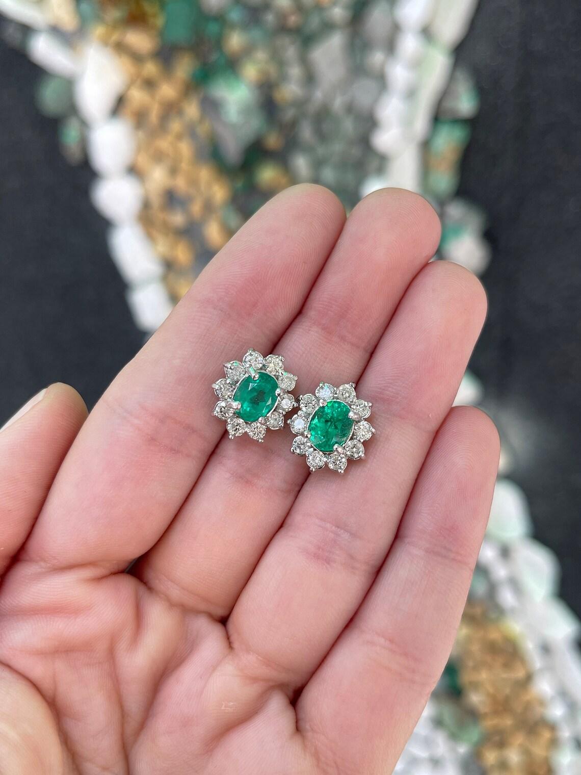 Indulge in the allure of our emerald and diamond halo stud earrings, a testament to refined elegance. These earrings boast exquisite oval-cut Colombian emeralds, radiating a vivacious rich green hue with semi-transparent clarity. With a combined