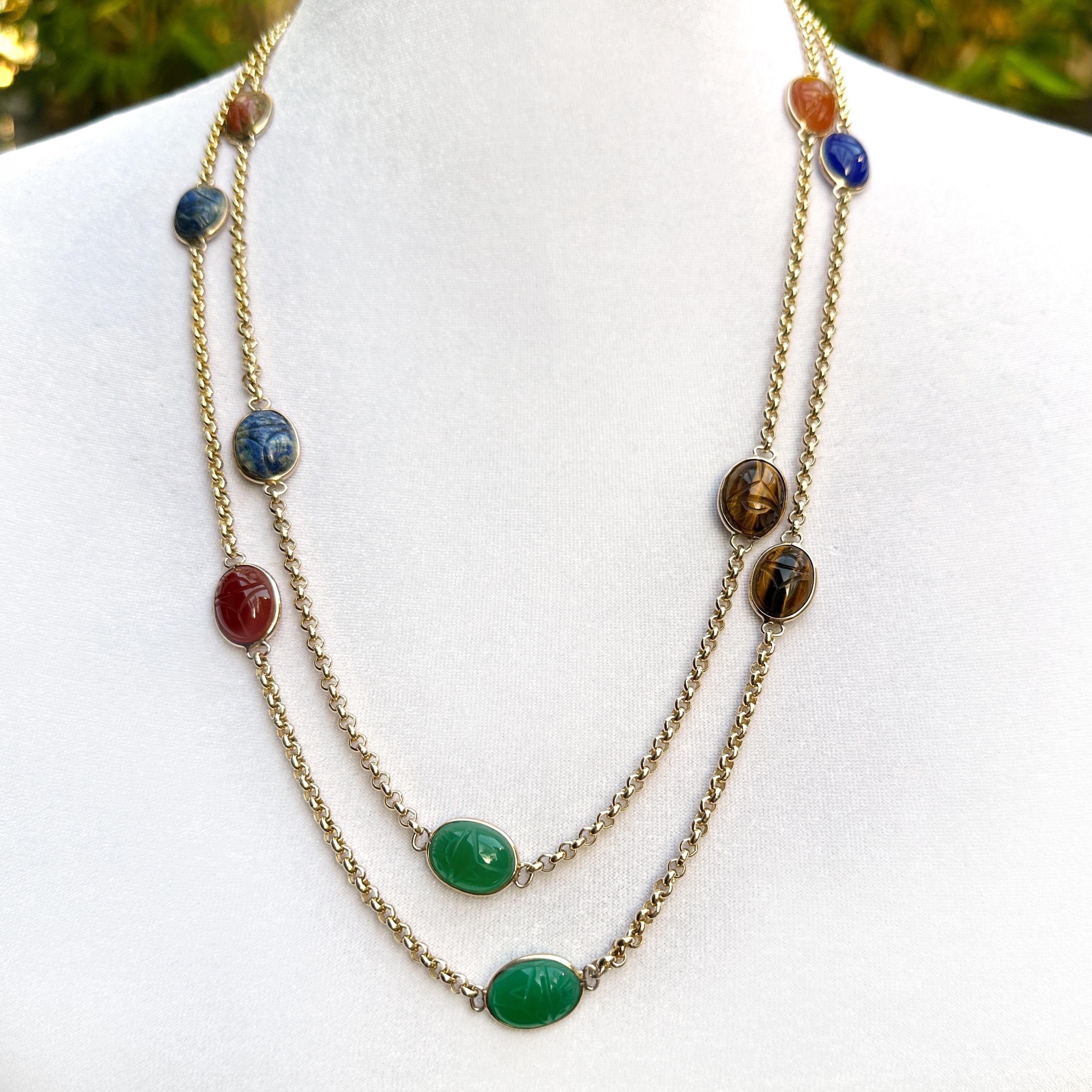 Cette chaîne extra-longue - de plus d'un mètre quatre-vingt-dix - est dotée d'un chaton ovale, chacun contenant une pierre semi-précieuse sculptée à l'image d'un scarabée.

Les pierres sont un mélange assez typique de pierres dures utilisées pour