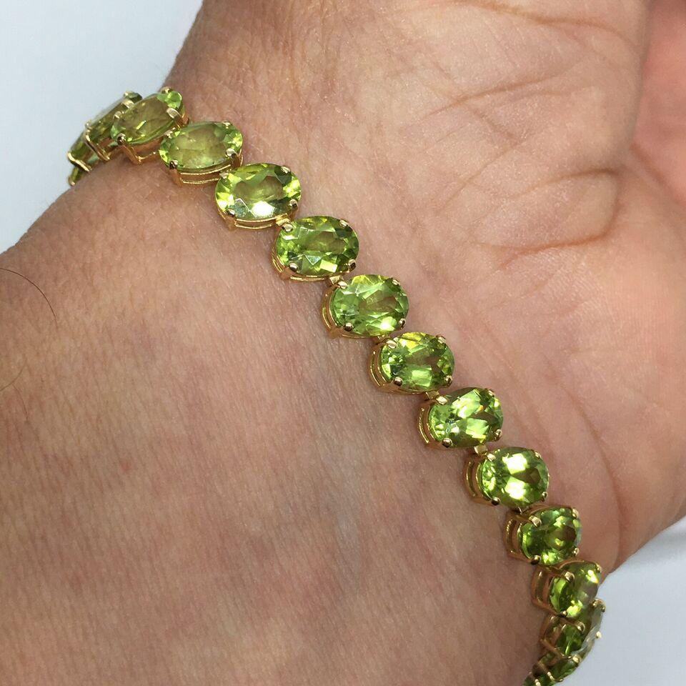 14K gold 7 mm by 5 mm 28 Oval Natural Peridot Tennis Bracelet Women 7.25 inch In Good Condition For Sale In Santa Monica, CA