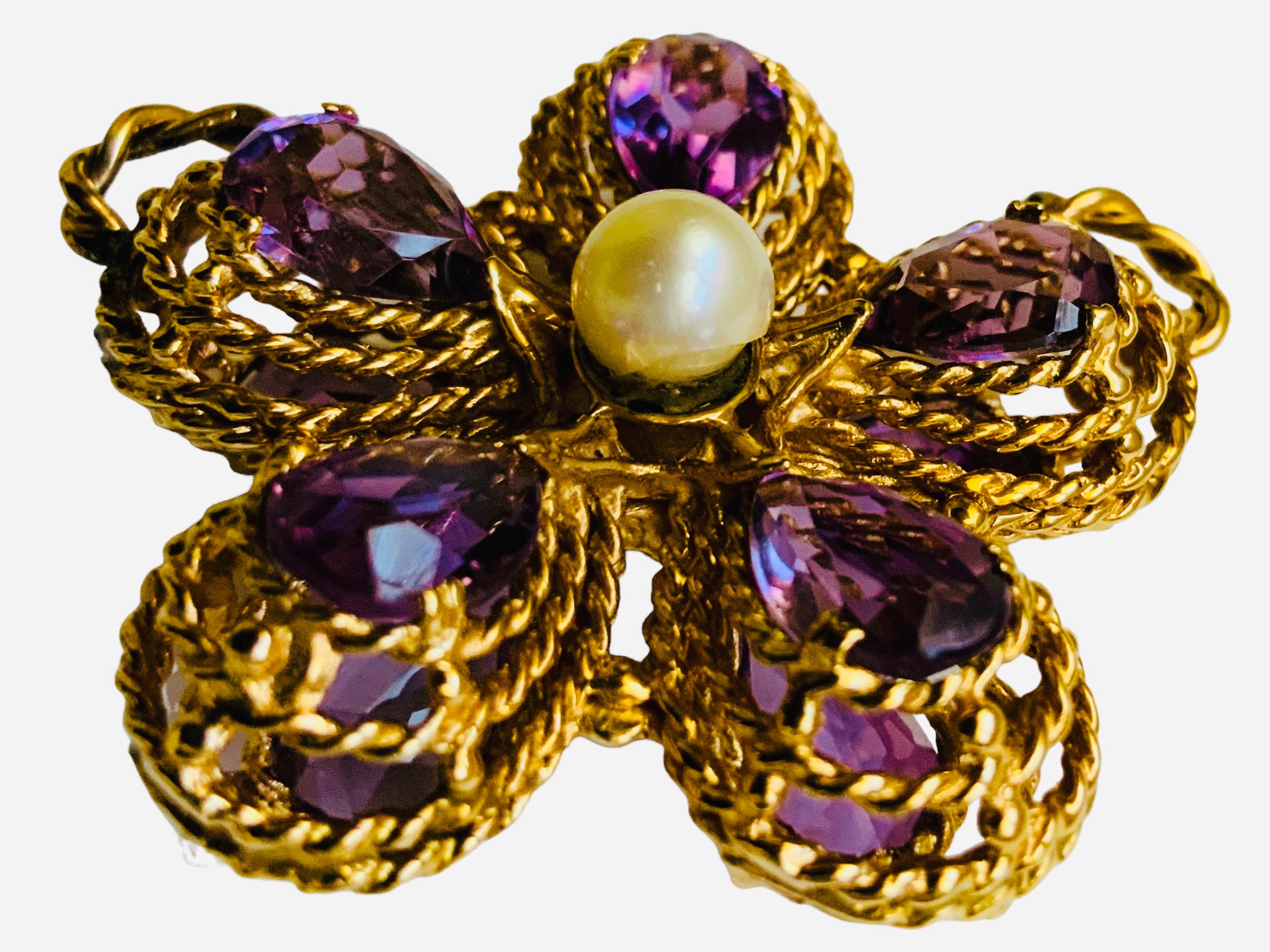 This is a 14K Gold Amethyst and Pearl Violet Flower Pendant. It depicts a front and back large violet flower petals made of ten pear shaped amethysts mounted in  several gold braided ropes and embellished in the center by two round pearls seated