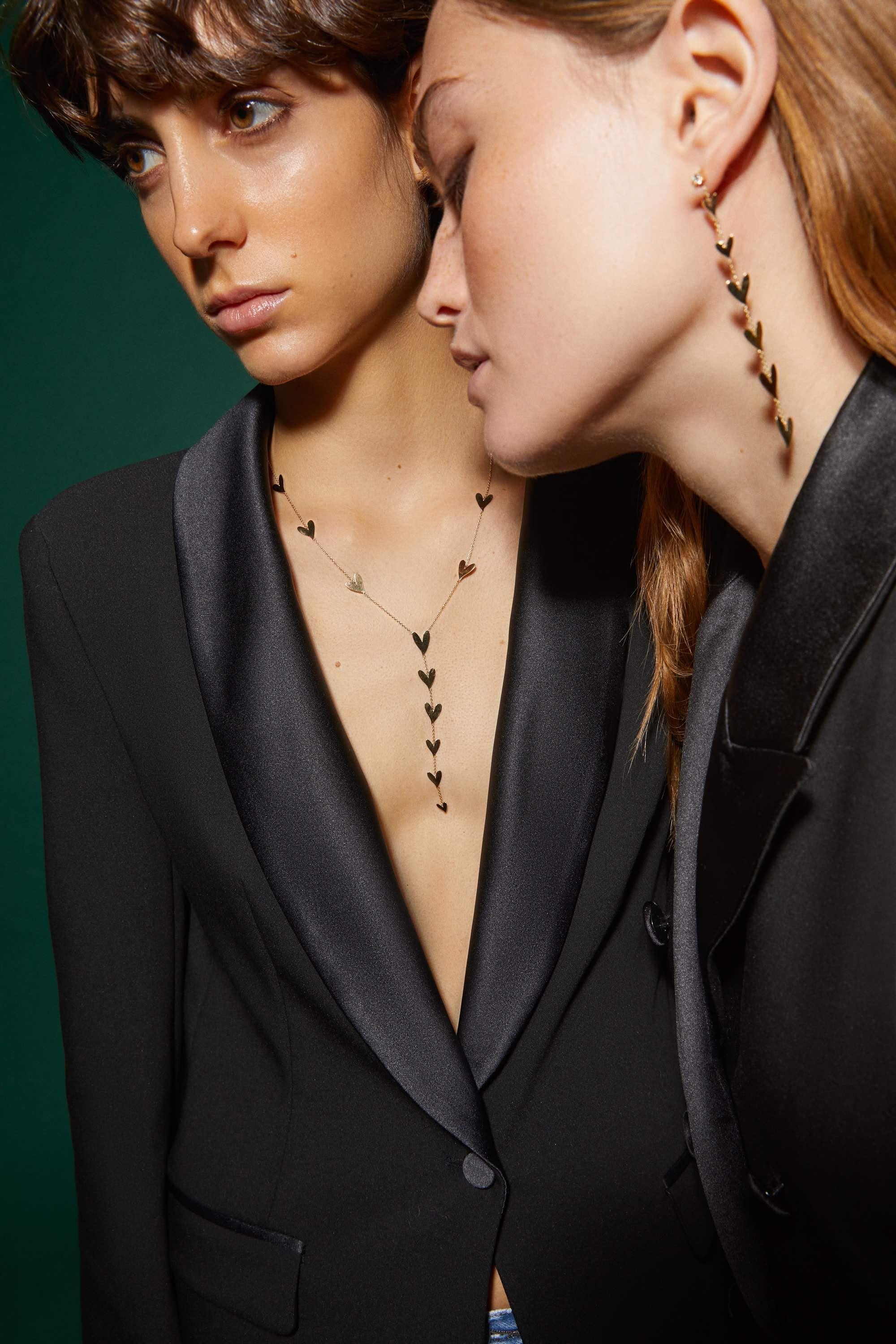 This beautiful chain earring is adorned with unique shaped little hearts from designer's childhood drawing and a 0.12ct solitaire diamond.
