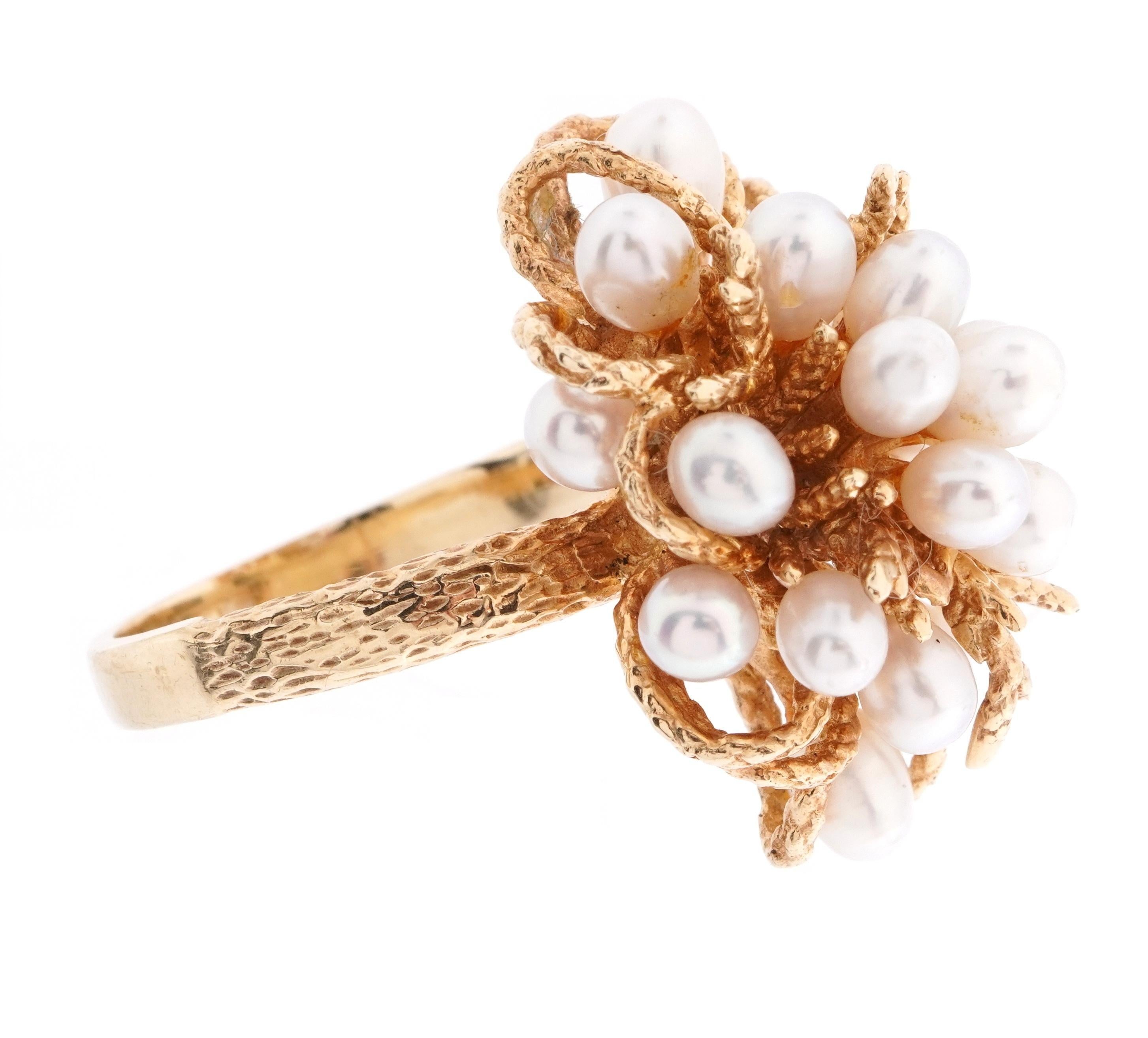 Anello da cocktail in oro giallo 14 carati con fascia parzialmente impunturata e un grappolo floriforme di 20 perle ovali. Taglia 6.5. 9,22 grammi di peso totale.