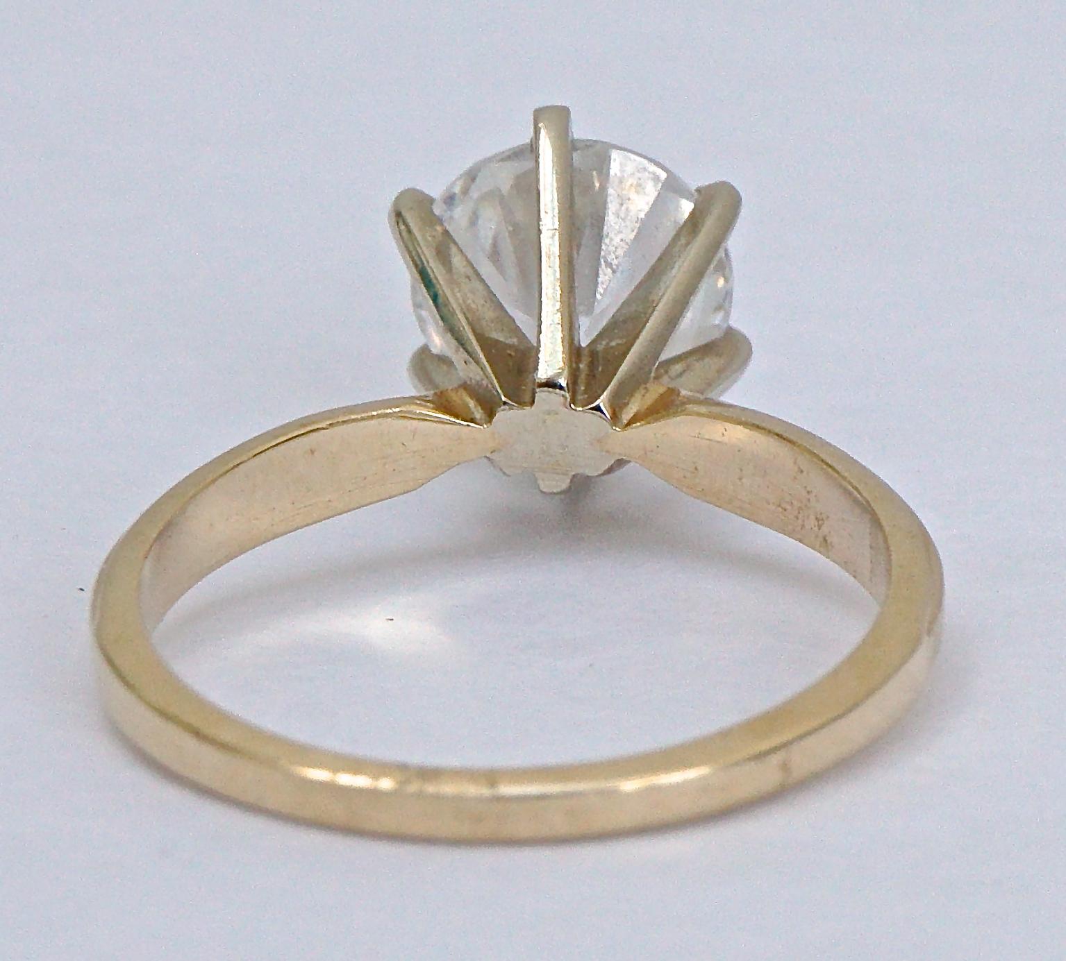 Bague solitaire en or 14K et zircon cubique diamanté, taille UK M / US 6, et pesant 3,4 g, vers les années 1990. La zircone cubique a un diamètre de 8 mm et le sertissage a une profondeur de 8,5 mm. La bande intérieure est estampillée 14K DQ CZ.