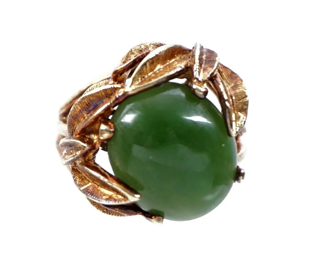 14k Gold and Jade Cabochon Floriform Ring. 
14k yellow gold band, floriform prong set center oval jade cabochon approx. 15mm x 11mm.  Size 6.  Approx. 10 grams inclusive.