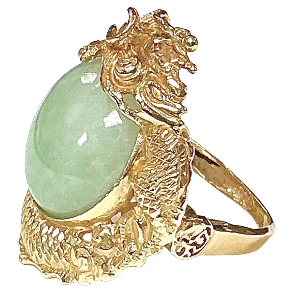 Chinese 14k Gold and Jade Dragon Ring. 14k yellow gold ring, reticulated dragon encircling a cabochon jade, 15mm dia.  Approx. size 5. 