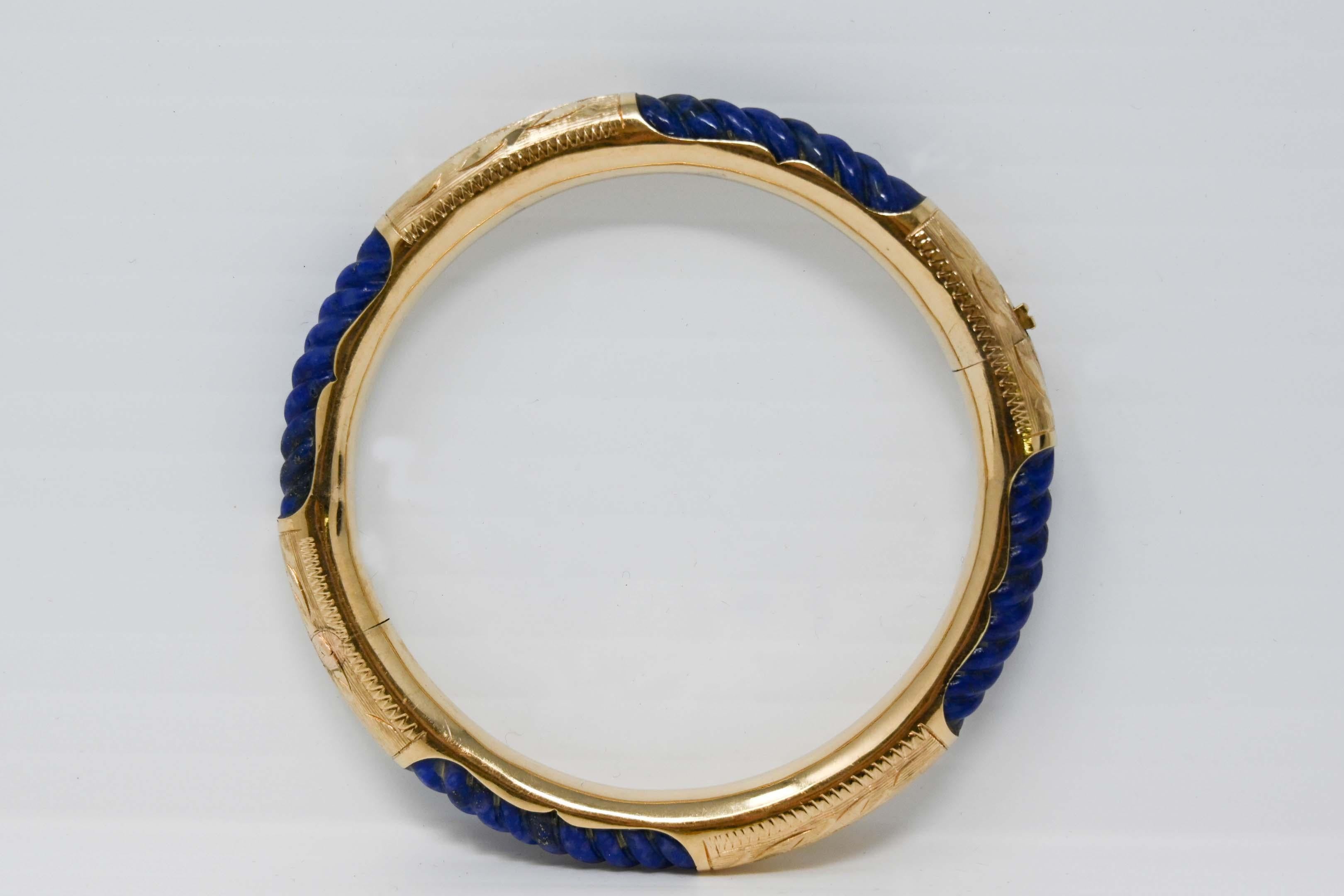 14k yellow gold and twisted Lapis Lazuli stone bangle bracelet. Measures 2 1/4 inches inside diameter and 2 3/4 inches outside. Weighs 23.3 grams. Stamped 14k, maker unknown.
