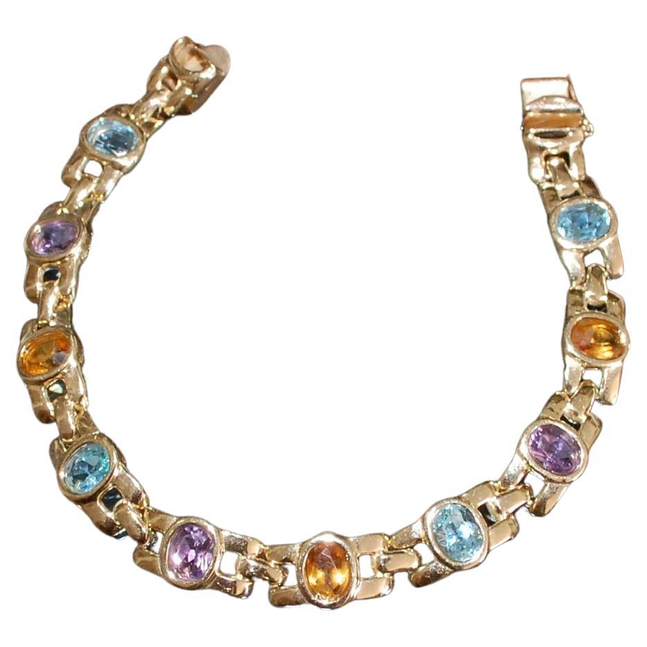 Elegante bracciale a maglie Estate con pietre semipreziose.
Splendido bracciale in oro giallo 14K, con 7 bellissime pietre multicolore ovali incastonate, tra cui 3 ametiste, 4 topazi blu e 3 citrini su maglie fantasia. Questo braccialetto misura 7,5