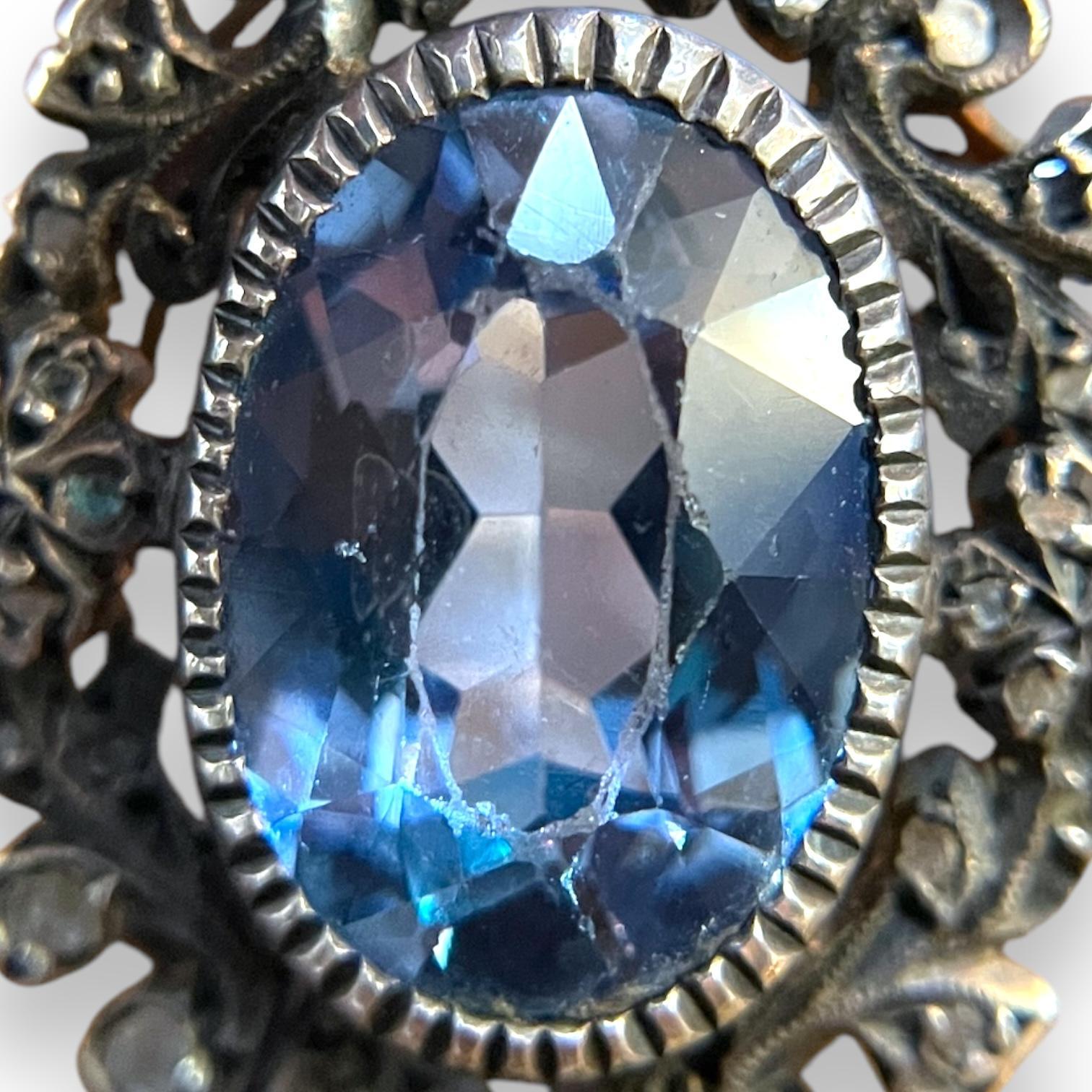 Ein atemberaubender Ring, der 14-karätige Goldakzente mit Sterlingsilber kombiniert und einen atemberaubenden ovalen Aquamarin in der Mitte präsentiert. Die filigranen Blumendetails unterstreichen seinen Vintage-Charme und machen ihn zu einer