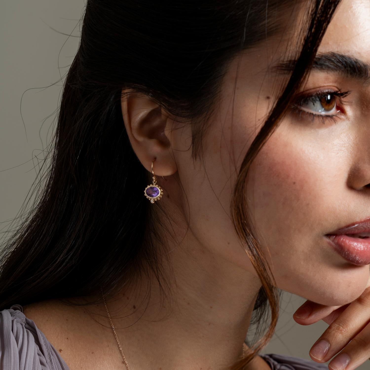 Inspired by creatures of the coral reef, this colourful Anemone collection is fascinating in its detailing. These dramatic drop earrings are set with oval amethyst in solid 14k yellow gold and feature granulated spheres around the outside of the