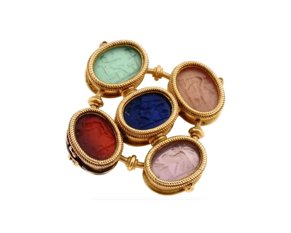 An antique Grand Tour 14K Gold and hand carved multi gemstones intaglio brooch. The brooch has five oval shaped medallions. Each medallion is adorned with a hand carved scene, decorated with a relief engraved border with a swirl motif. Circa: early
