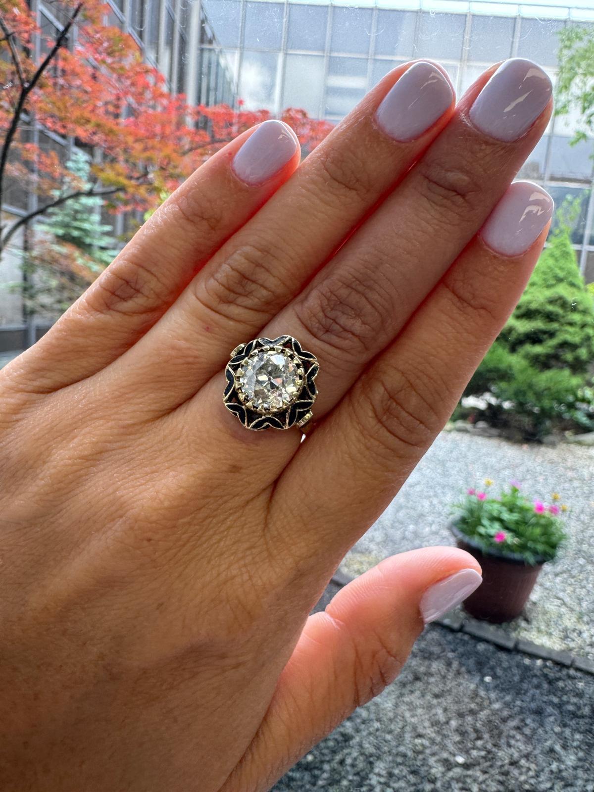 Un sorprendente anello antico realizzato in oro giallo 14K con audaci dettagli in smalto nero, con al centro un impressionante diamante tagliato da una vecchia miniera del peso di circa 2,65 carati. Il diamante mostra la classica forma a cuscino, la