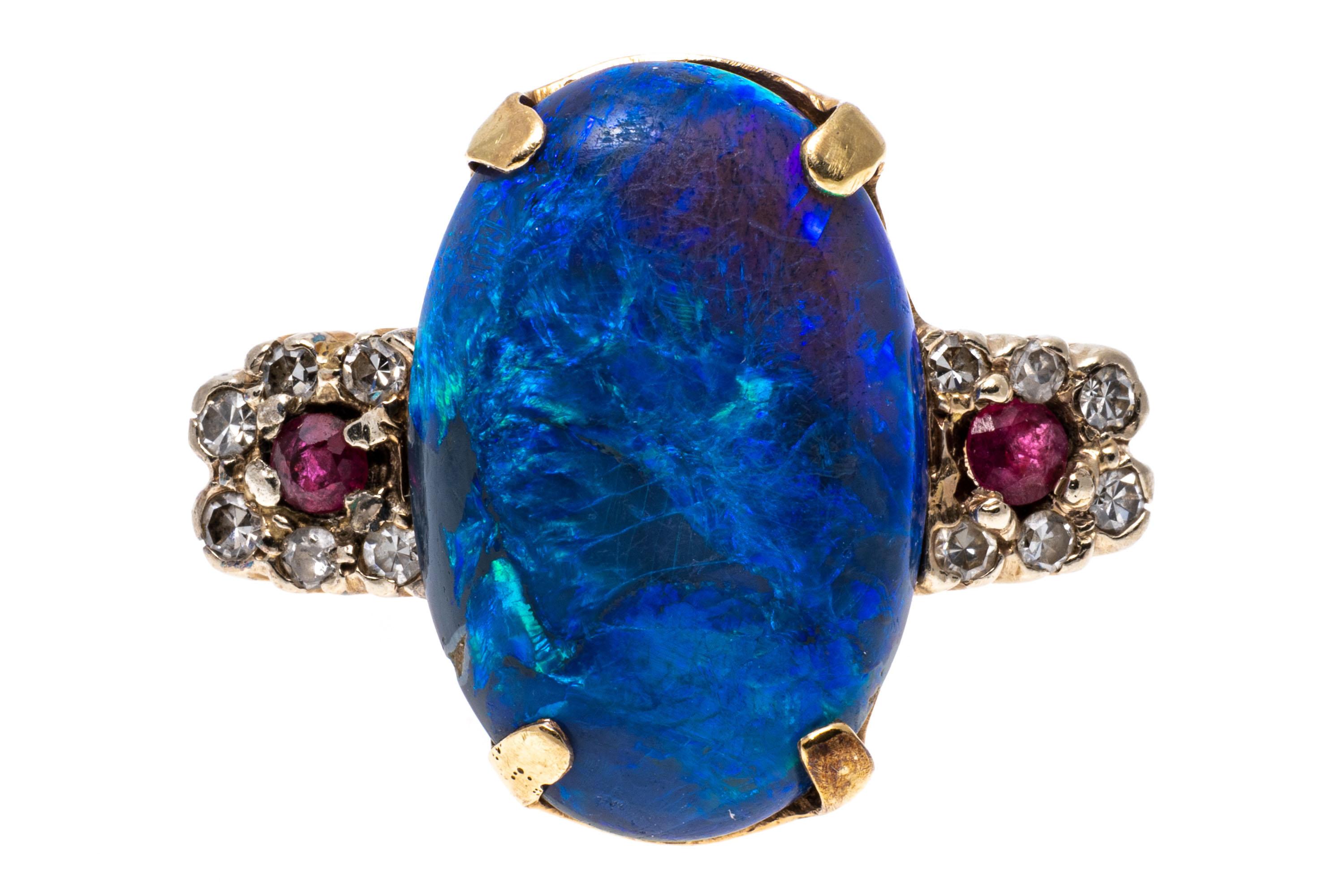 This stunning 14k yellow gold ring has an amazing long oval cabochon, blue-color black opal 8.16 CTS, prong set, and flanked with two round faceted pinkish red color rubies, approximately 0.10 TCW, framed with round faceted diamonds, approximately