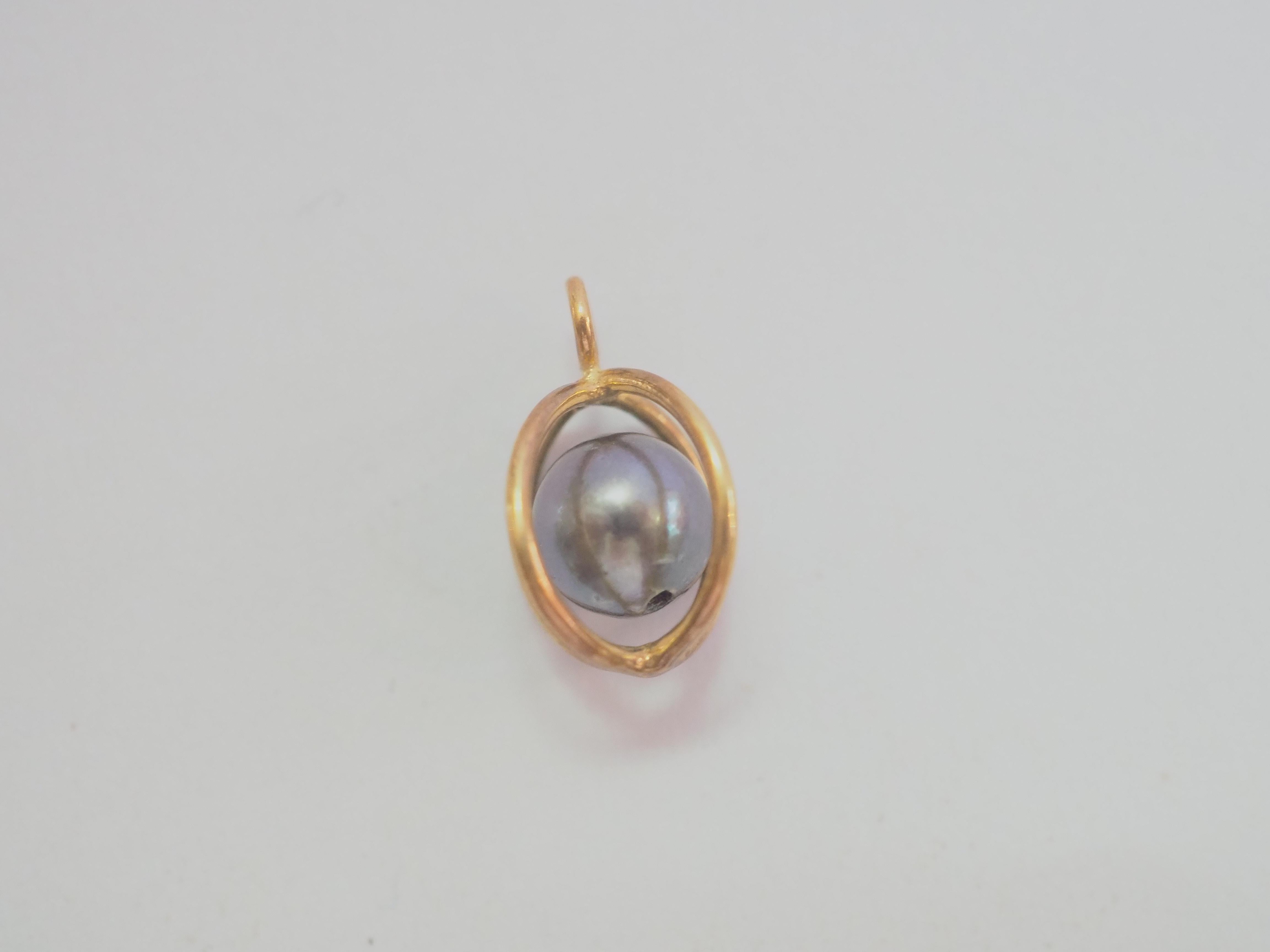 A beautiful and dainty pendant enhancer. This dainty piece is crafted using 14K solid yellow gold. The piece is adorned with a gorgeous black pearl set/caged inside the gold mounting moving freely inside the cage. This piece can be a wonderful and