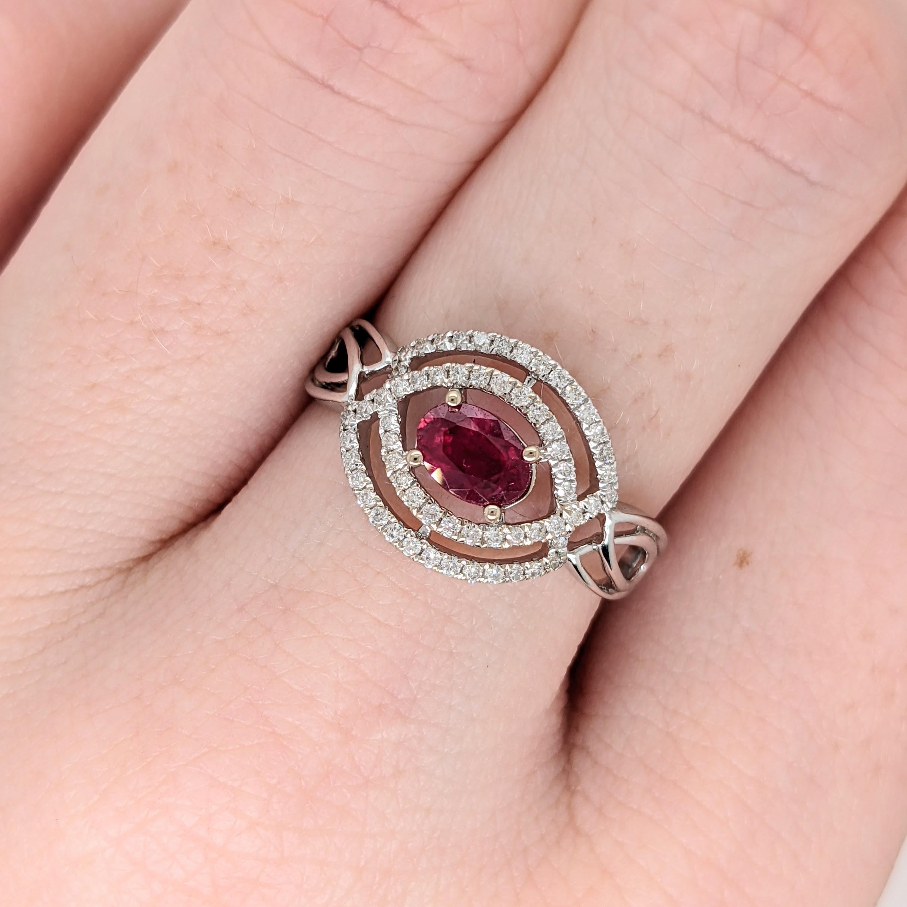 Ein fesselnder Cocktailring mit einem tiefroten Rubin aus Mosambik in der Mitte, der von funkelnden Diamanten aus Erdmineralien umrahmt wird. Der aus massivem 14-karätigem Weißgold gefertigte Ring zeigt ein verschlungenes keltisches Design, das