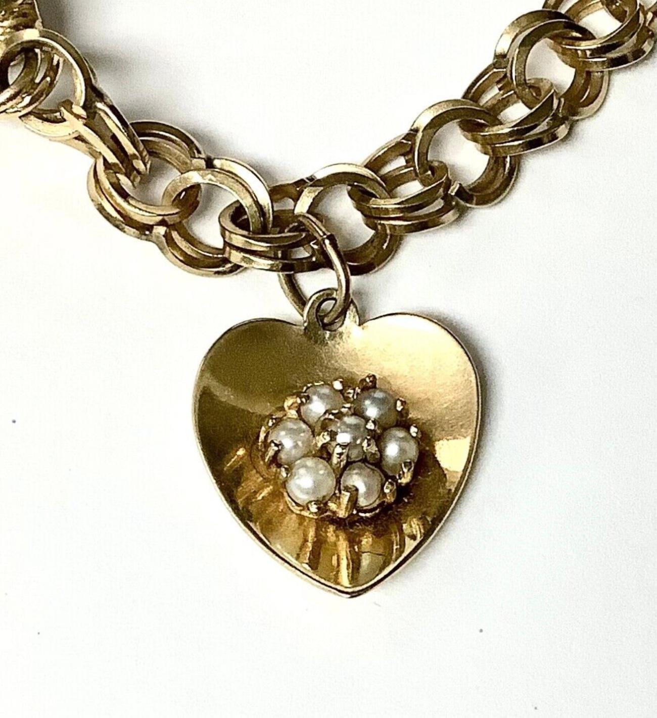 14k yellow gold chain bracelet with cluster of pearls in heart charm. 7 1/2 inches.
Marked 14k. 