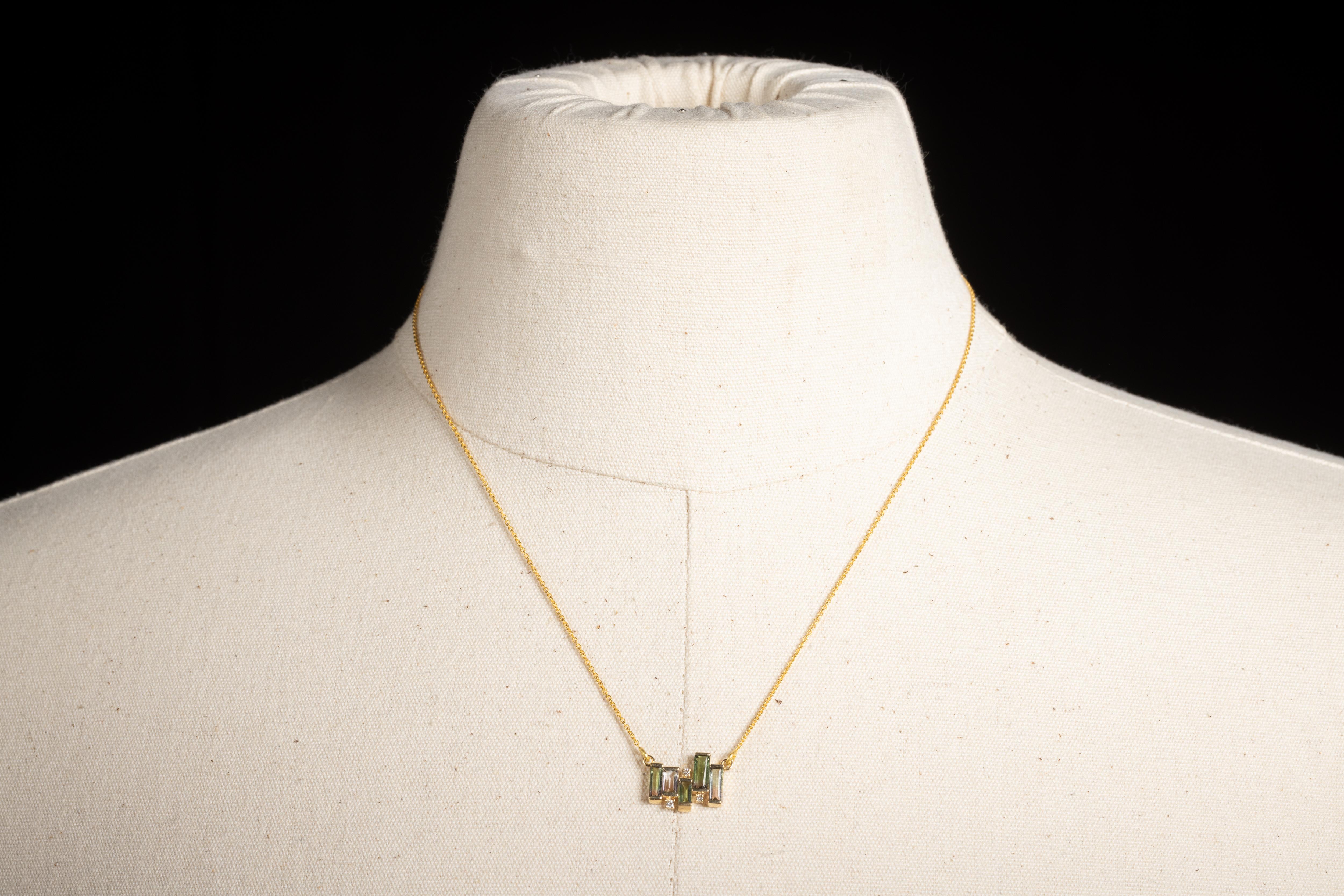 A delicate 14K gold chain necklace featuring a cluster of five emerald-cut green tourmaline gemstones interspersed with three round, brilliant cut diamonds. The chain has the option of three lengths--15