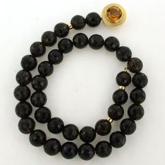 14k gold clasp on a garnet bead necklace with gold centerpiece with citrine