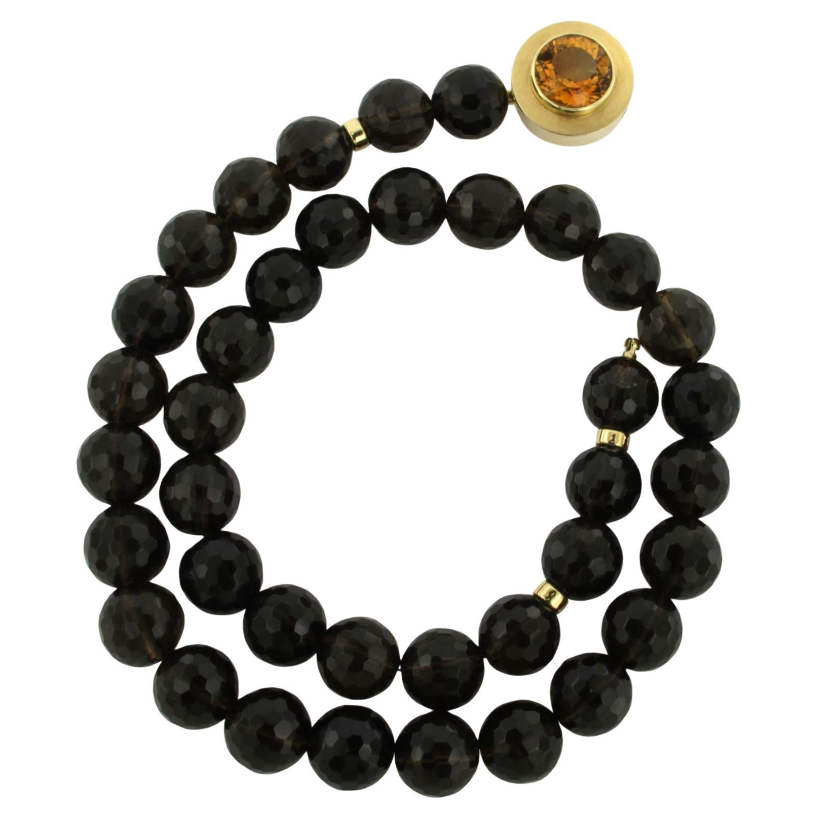 14k gold clasp on a garnet bead necklace with gold centerpiece with citrine