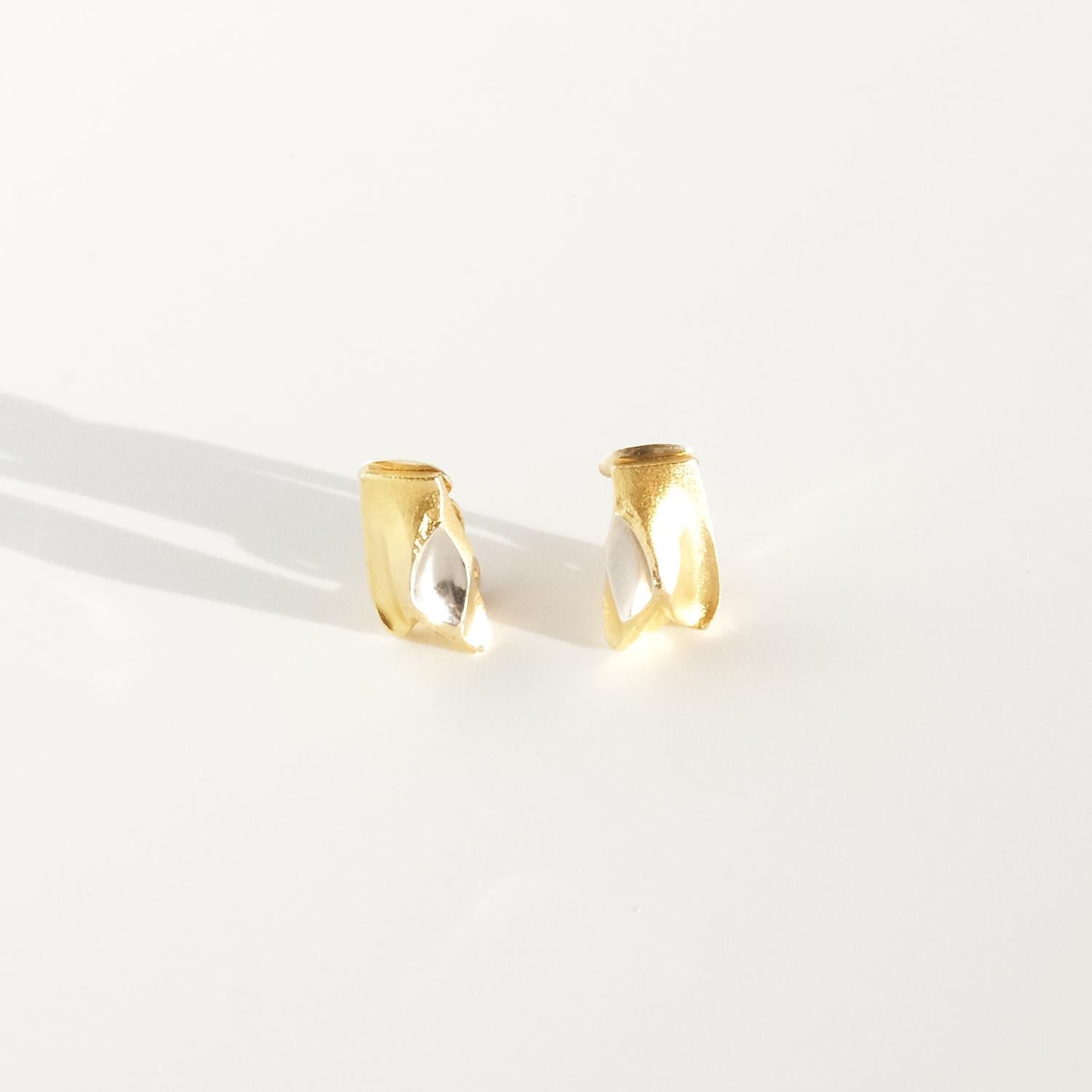 Diese Ohrringe aus 14-karätigem, zweifarbigem Gold zum Anstecken wurden von Björn Weckström entworfen und heißen Episode. Sie haben eine rechteckige, gewellte Form. Die Oberfläche des Gelbgoldes ist matt und halbglänzend, während die Oberfläche des