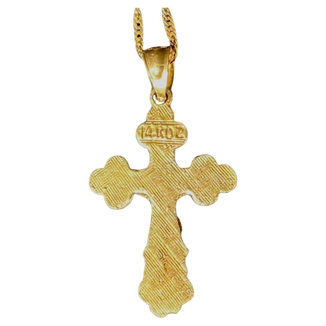 14K Gold Cross Pendant featuring an intricate design with a raised depiction of the crucifix. The ornate ends of the cross arms are delicately shaped and textured, adding depth and visual interest. 
Cross pendant measures approximately 1 inch in