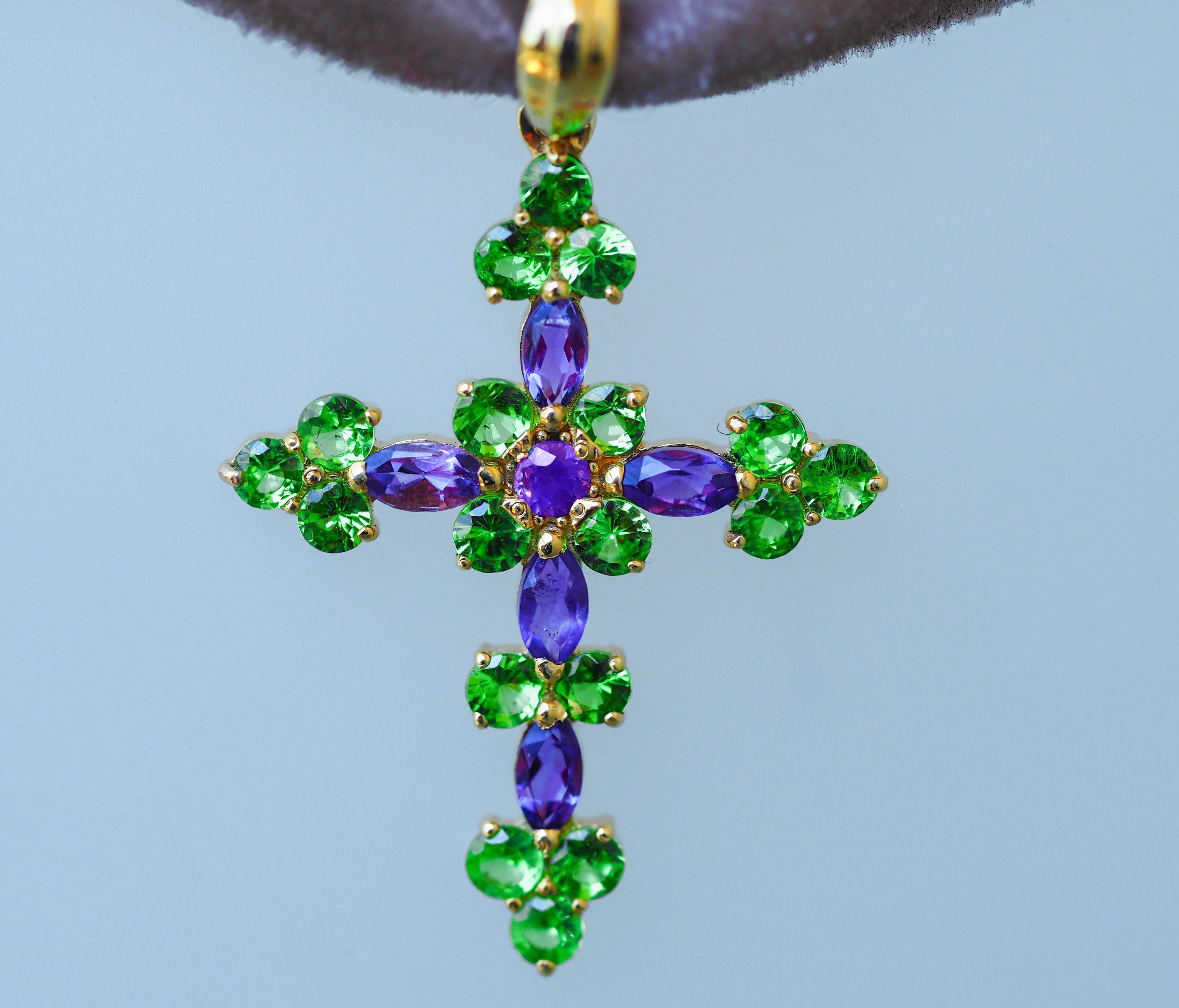 14 kt solid gold Cross pendant with natural colored stones: amethysts and tsavorite (green garnet)

Weight: 1.9 g.
Gold: 14kt solid yellow gold
Size: 31 x 19 mm.
Natural stones:
1. Tsavorite garnet: round cut, green color, transparent, approx 0.50