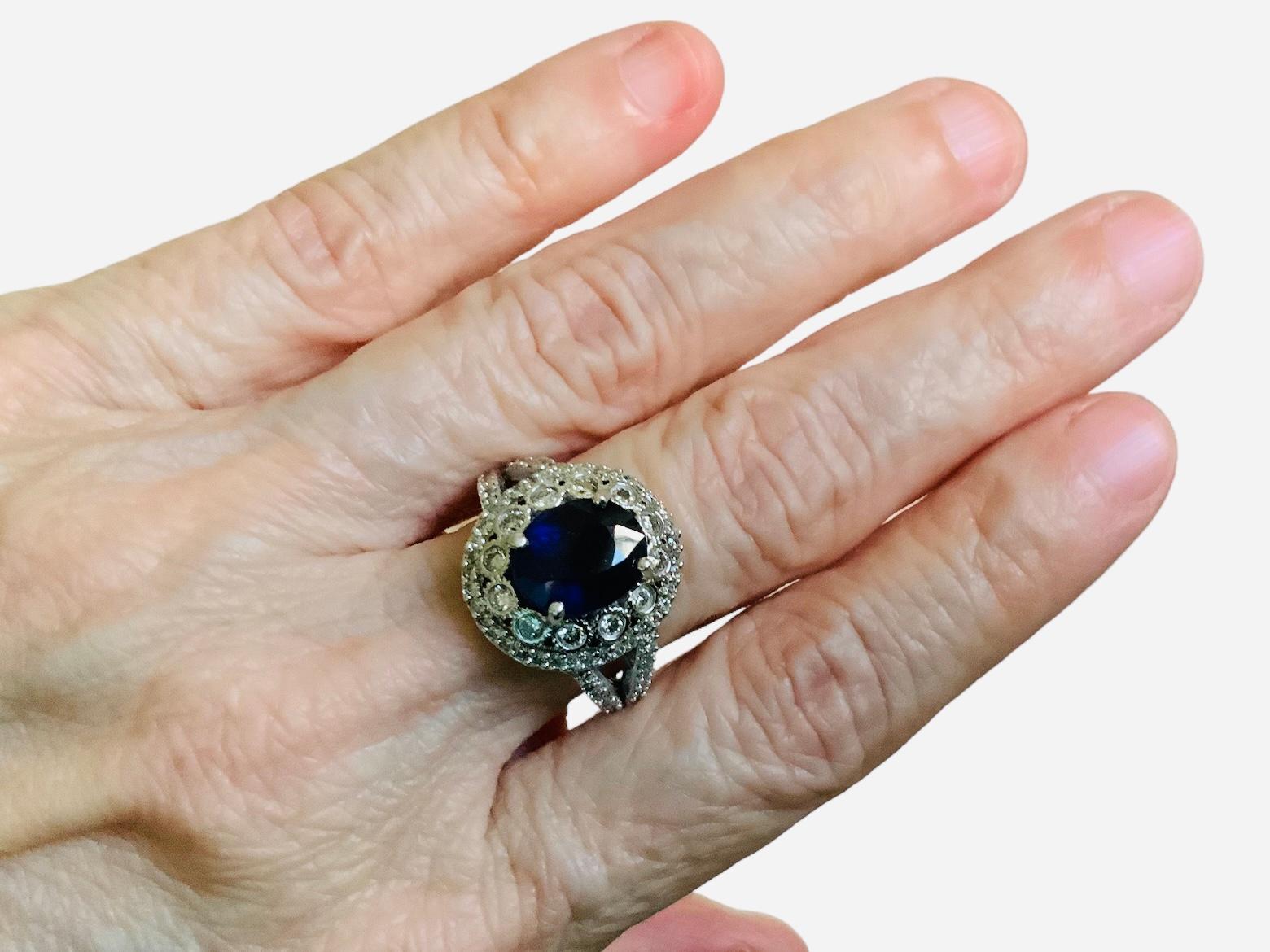 This is a 14K White Gold, Diamonds and Sapphire Ring. It depicts a queen like ring consisting of an intense royal blue color oval shape cut natural sapphire ( Quality- AA, Carat Weight- 3.35) and 82 natural round diamonds( Color- I-J, Quality-