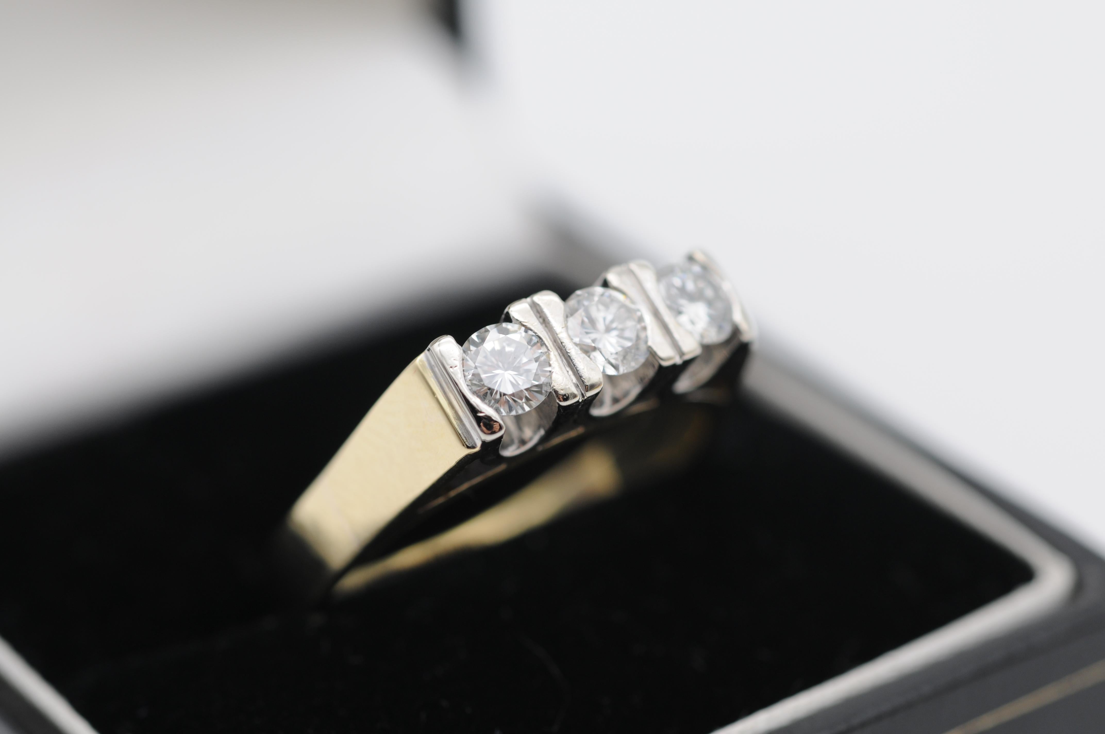This 14k gold diamond band ring is a classic and timeless piece of jewelry that exudes elegance and sophistication. The ring features three dazzling diamonds that sparkle with brilliance and fire, with a total carat weight of approximately 0.60