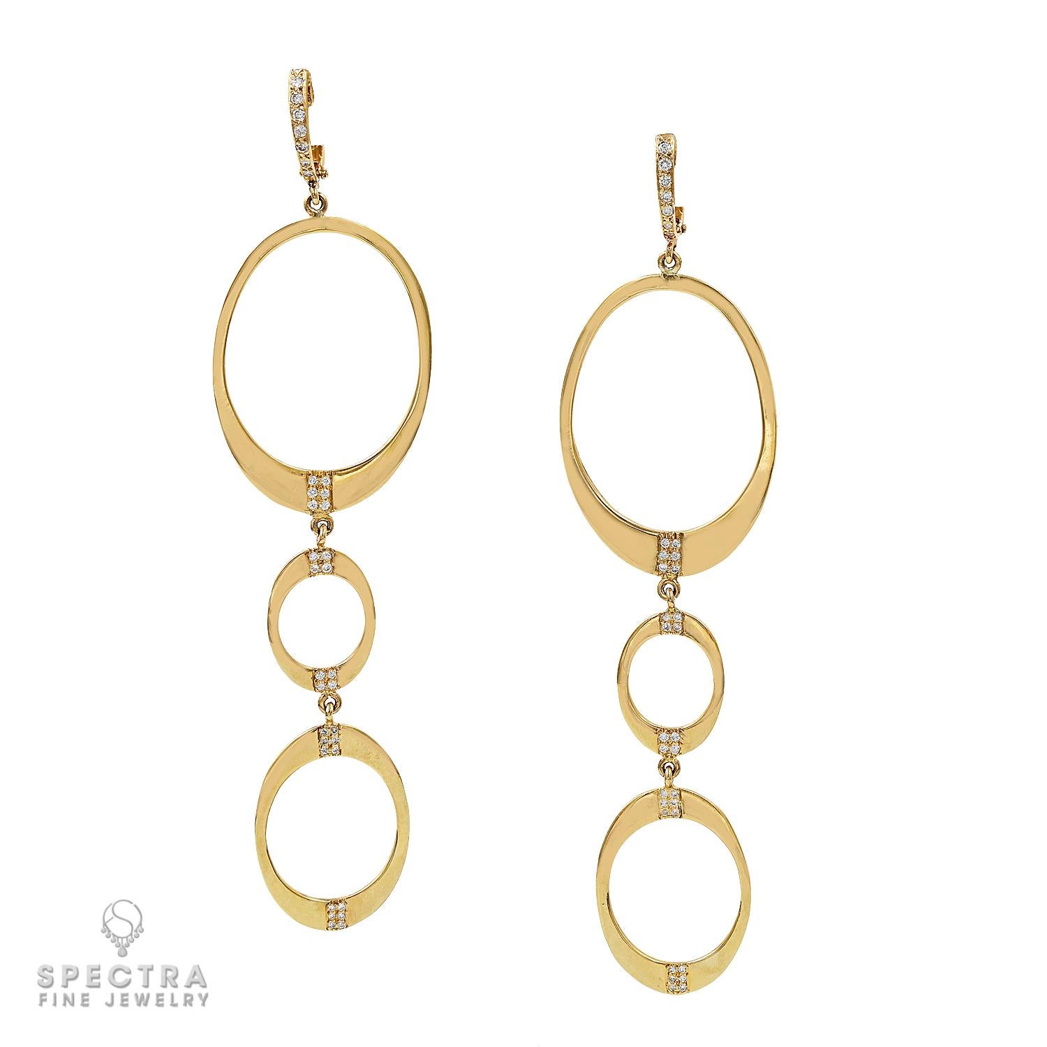 These captivating elongated earrings are meticulously crafted from premium 14k yellow gold, boasting three graceful hoops intricately linked to form a mesmerizing cascade of radiant gold. The largest hoop, measuring approximately 1.5 inches at its
