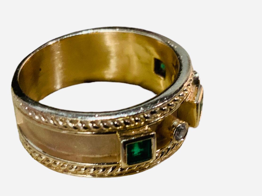 Dies ist ein 14K Gelbgold, Diamanten und Smaragde Band Ring. Er enthält drei quadratische Smaragde mit einem Gewicht von 0,45 Karat und zwei runde Brillanten mit einem Gewicht von 0,05 Karat (Farbe G-H, Reinheit VS-gut), die jeweils in einer Fassung