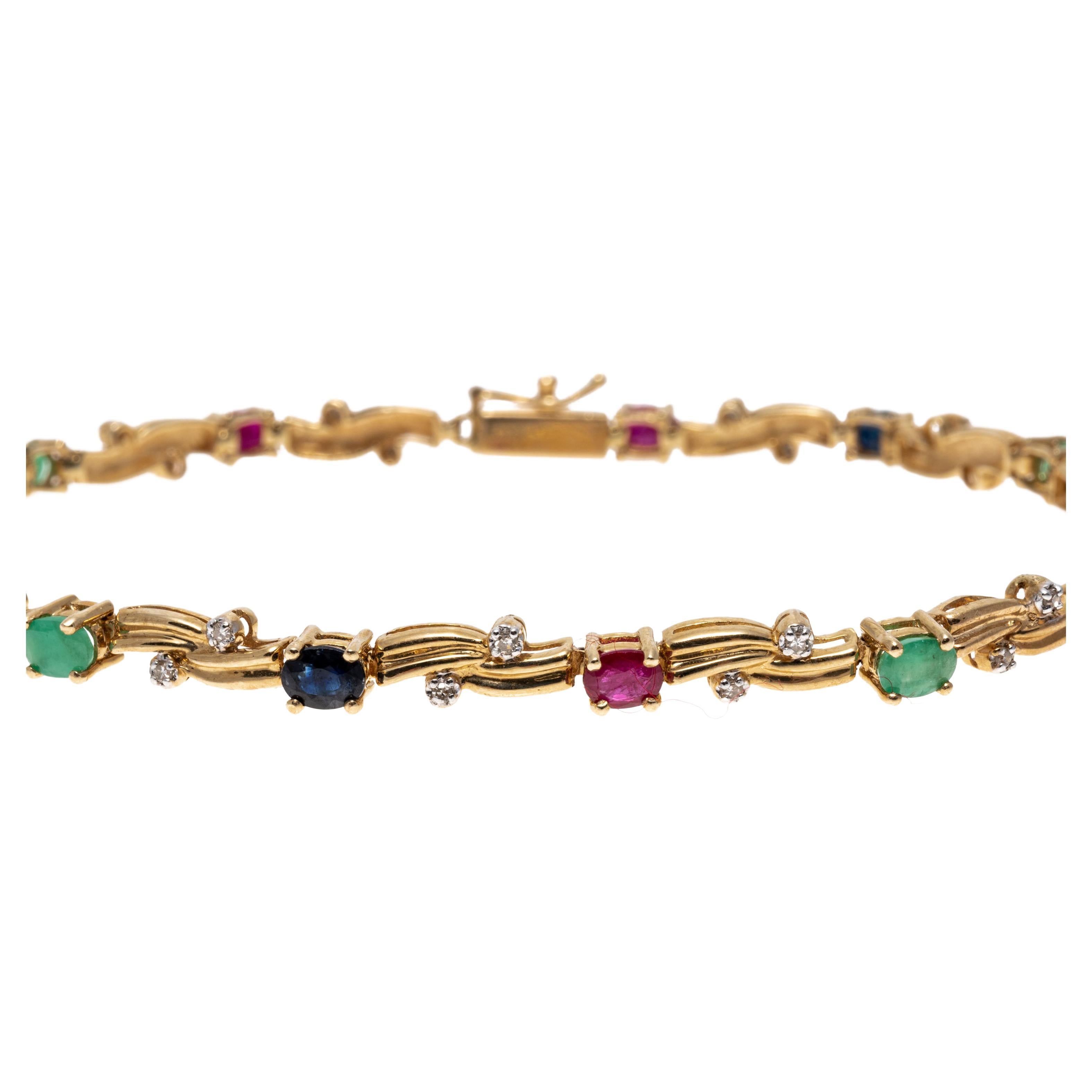 Set with alternating oval cut rubies, sapphires and emeralds, this 14K yellow gold line bracelet adds a delicate touch. Set between each of the stones are two round cut diamonds adding a slight shimmer. The diamonds are approximately 0.7 TCW, rubies