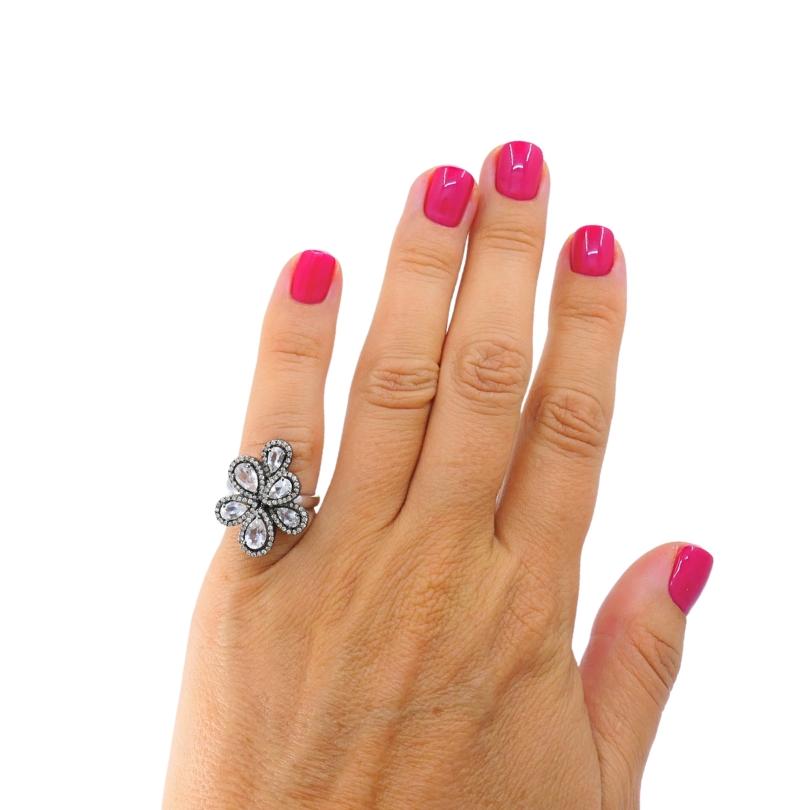 
Cette étonnante bague de cocktail en or 14k est conçue dans un design floral audacieux, centré sur six diamants taillés en rose en forme de poire, chacun disposé dans un motif de fleur rayonnante. Chaque diamant est entouré d'un halo de diamants