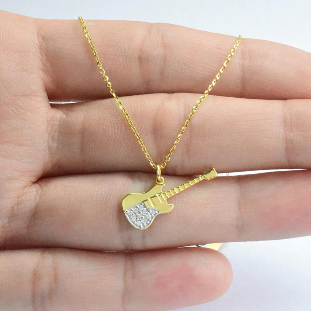 Le collier à breloque guitare en diamant est fabriqué en or massif 14k.
Disponible en trois couleurs d'or : Or jaune / Or rose / Or blanc.

Délicat collier à breloques guitare avec diamant naturel en or 14k. Ce collier minimaliste moderne est un