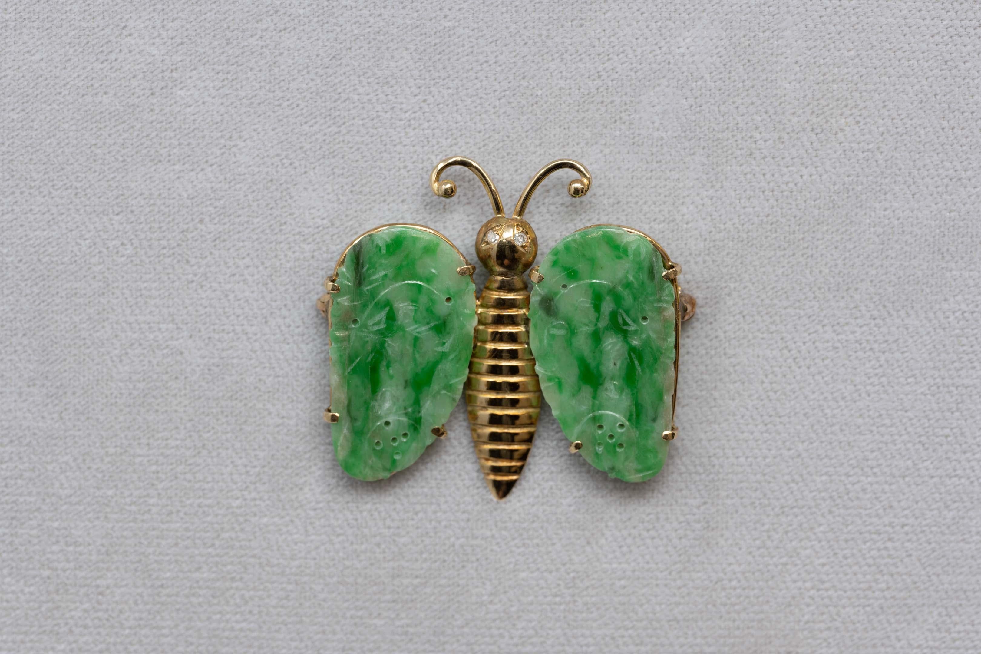 14k acid tested butterfly shaped brooch set with two diamonds on the eyes and two carved jadeite's which measures 25mm x 14mm each. White to vivid green color. The brooch is unmarked, measures 35mm x 33mm. Come with COA. 5.8 grams.

