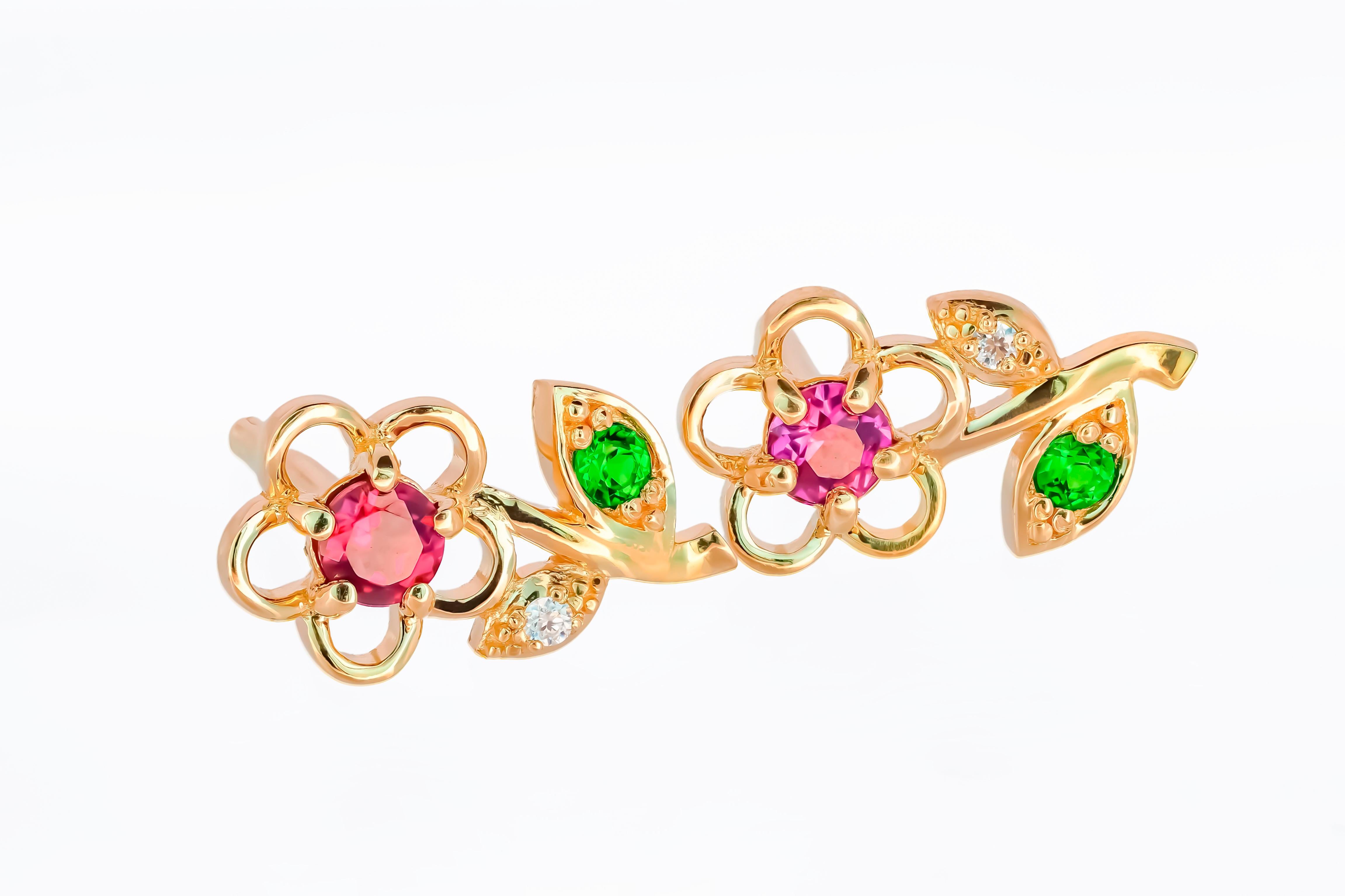14 karat gold earrings studs with genuine garnets, tsavorites and diamonds. January birthstone.
Metal: 14 karat gold 
Weight: 1.95 g.
Size: 13 x 6 mm.
Central stones:
Genuine garnets: weight - 0.08 ct x 2 = 0.16 ct total, red and purple color.
Round