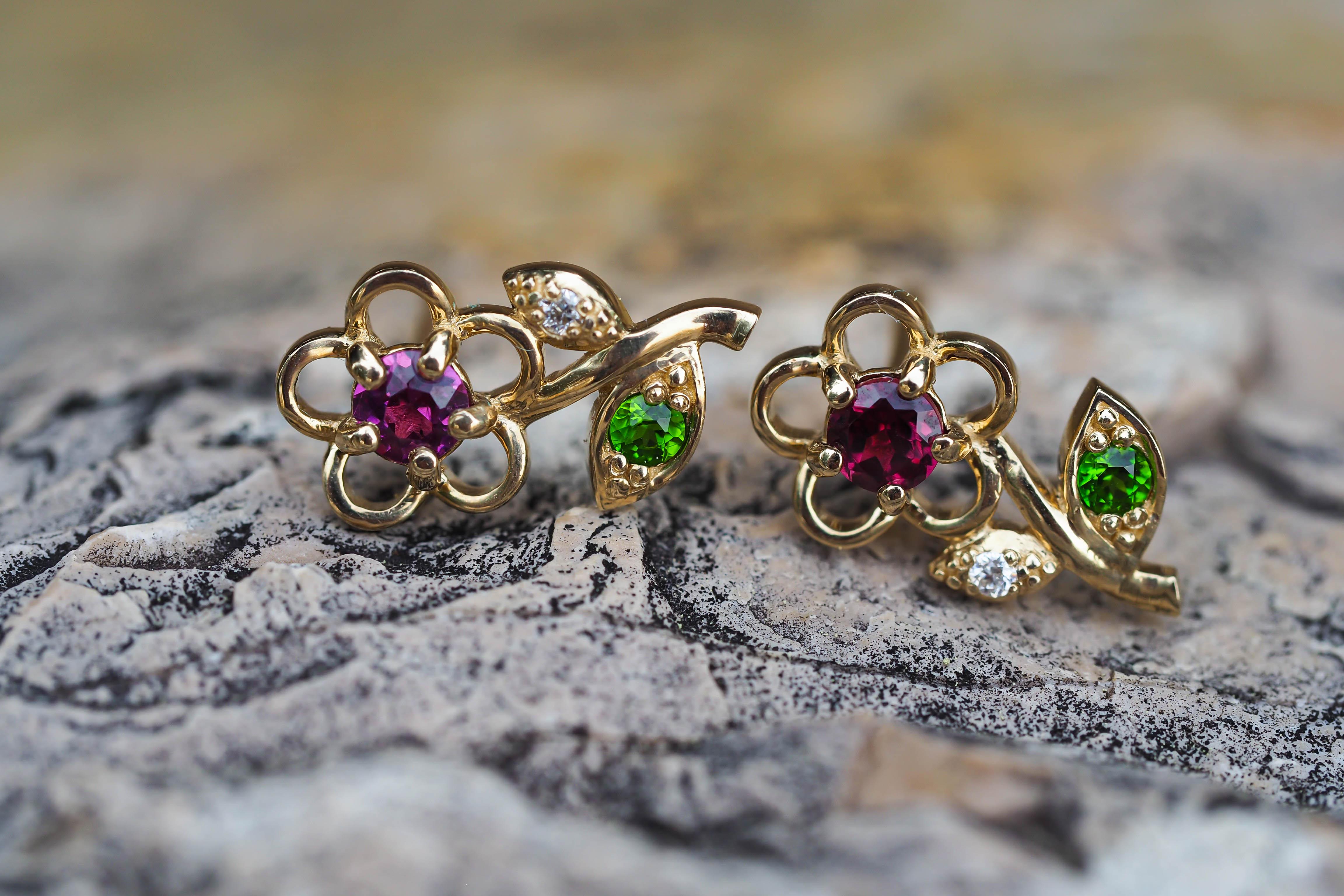 14k gold earrings studs with garnets, tsavorites and diamonds. Flower design studs with multicolor gemstones. Contemporary design earrings.

metal: 14k gold 
weight: 1.75 gr
size: 13x6mm
set with garnets: red and purple color, round cut, clarity