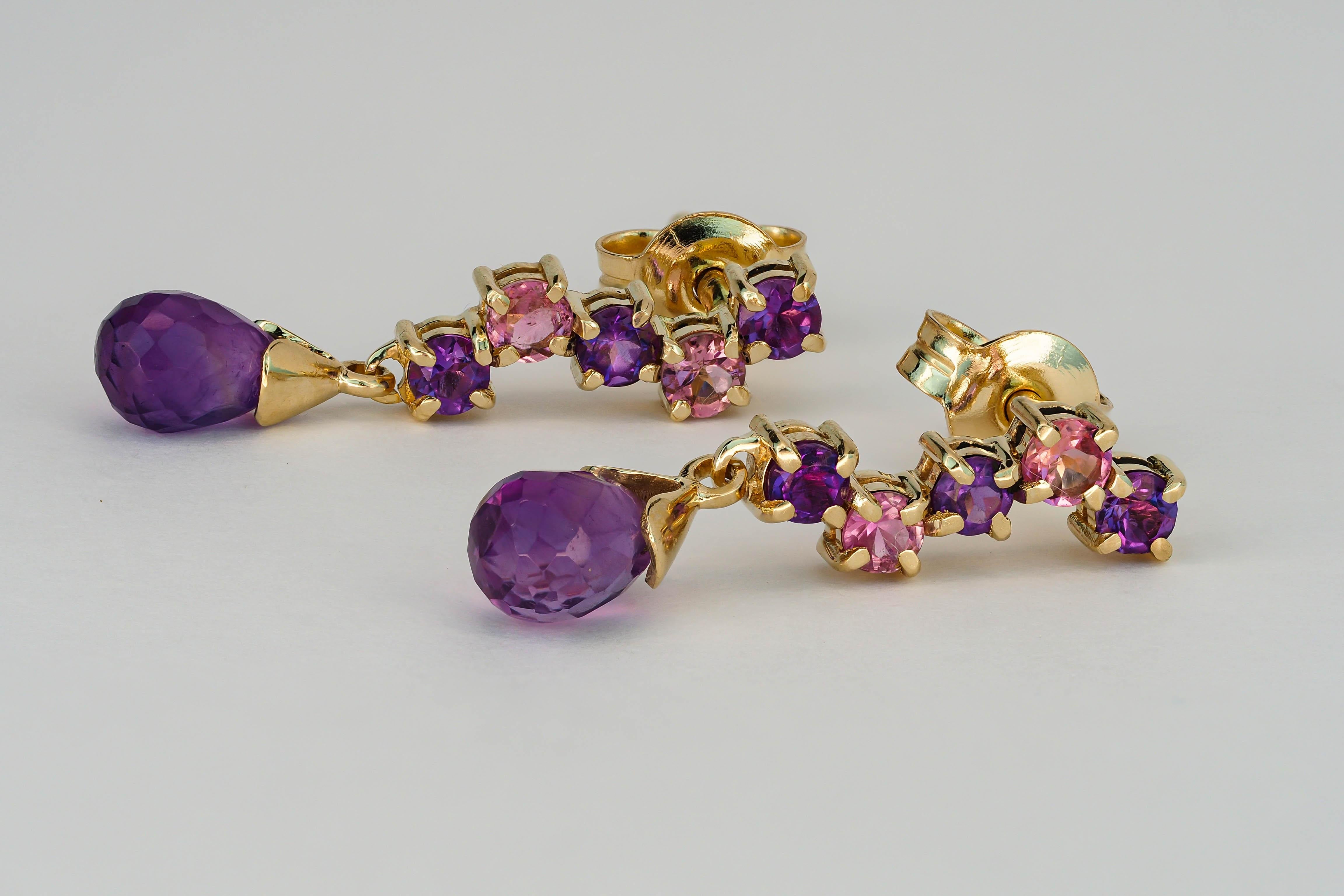 14k gold earrings with amethysts and sapphires.

Total weight: 2.20 g.
Size: 22 x 5 mm.
Central stones:
Amethysts - 2 pieces
Cut: Briolettes
Weight: approx 2.00 ct. total.
Color: violet
Clarity: Transparent with inclusions

Side stones:
Amethysts: 6